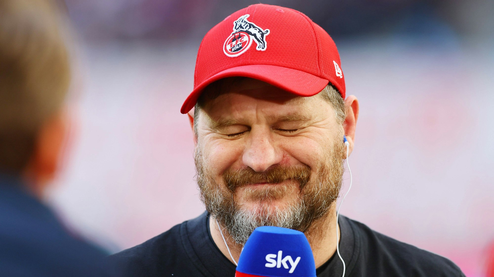 Trainer Steffen Baumgart grinst am Sky-Mikro.