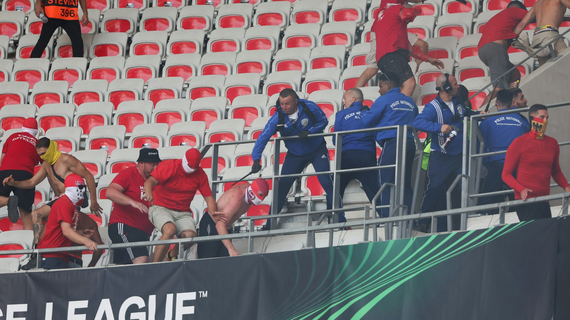 Sicherheitskräfte gehen im Stadion von Nizza gegen teilweise vermummte Anhänger auf der Tribüne vor.