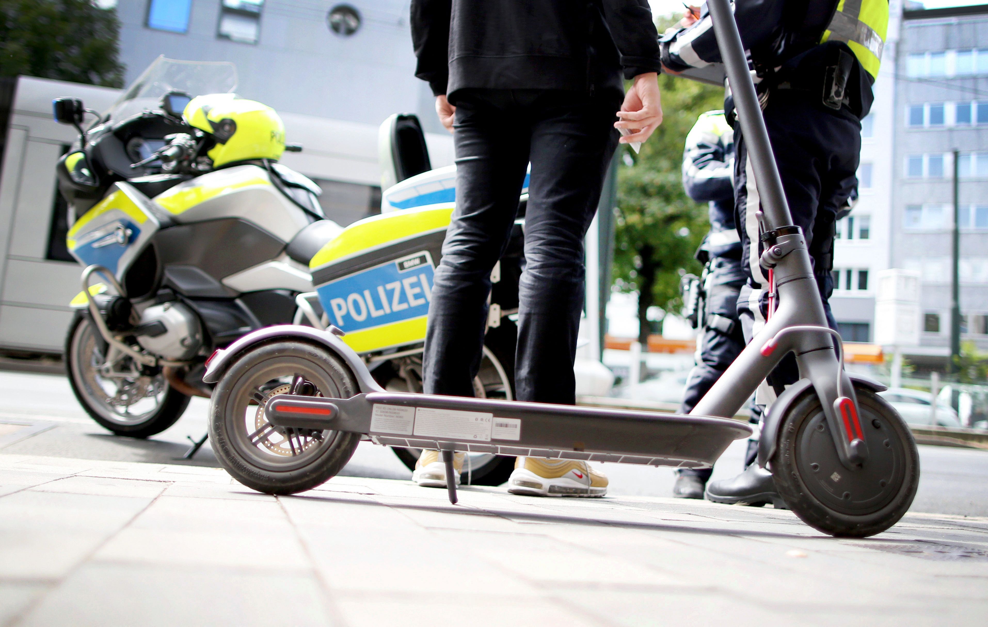 Polizisten kontrollieren einen E-Scooter-Fahrer.