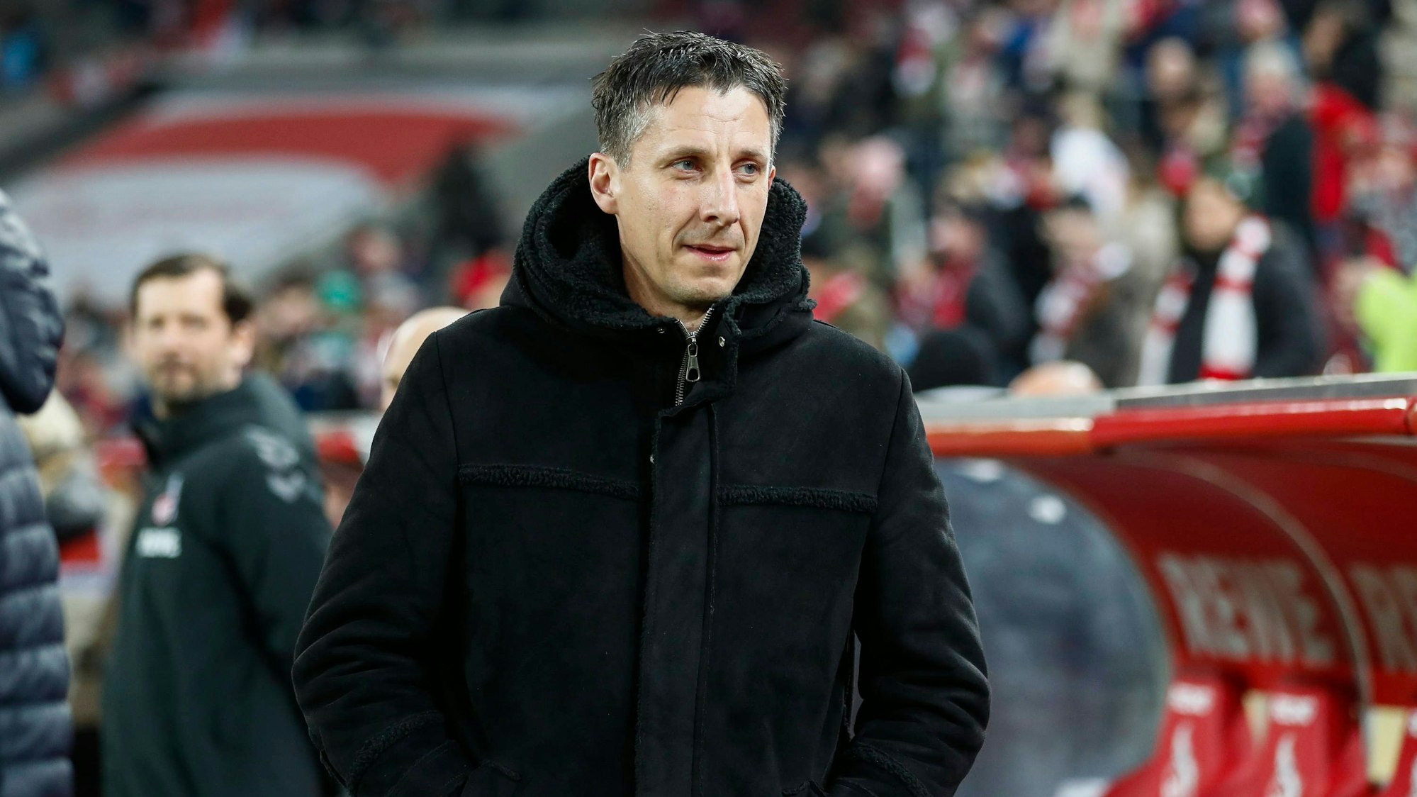 Christian Keller steht im Rhein-Energie-Stadion vor der Trainerbank.