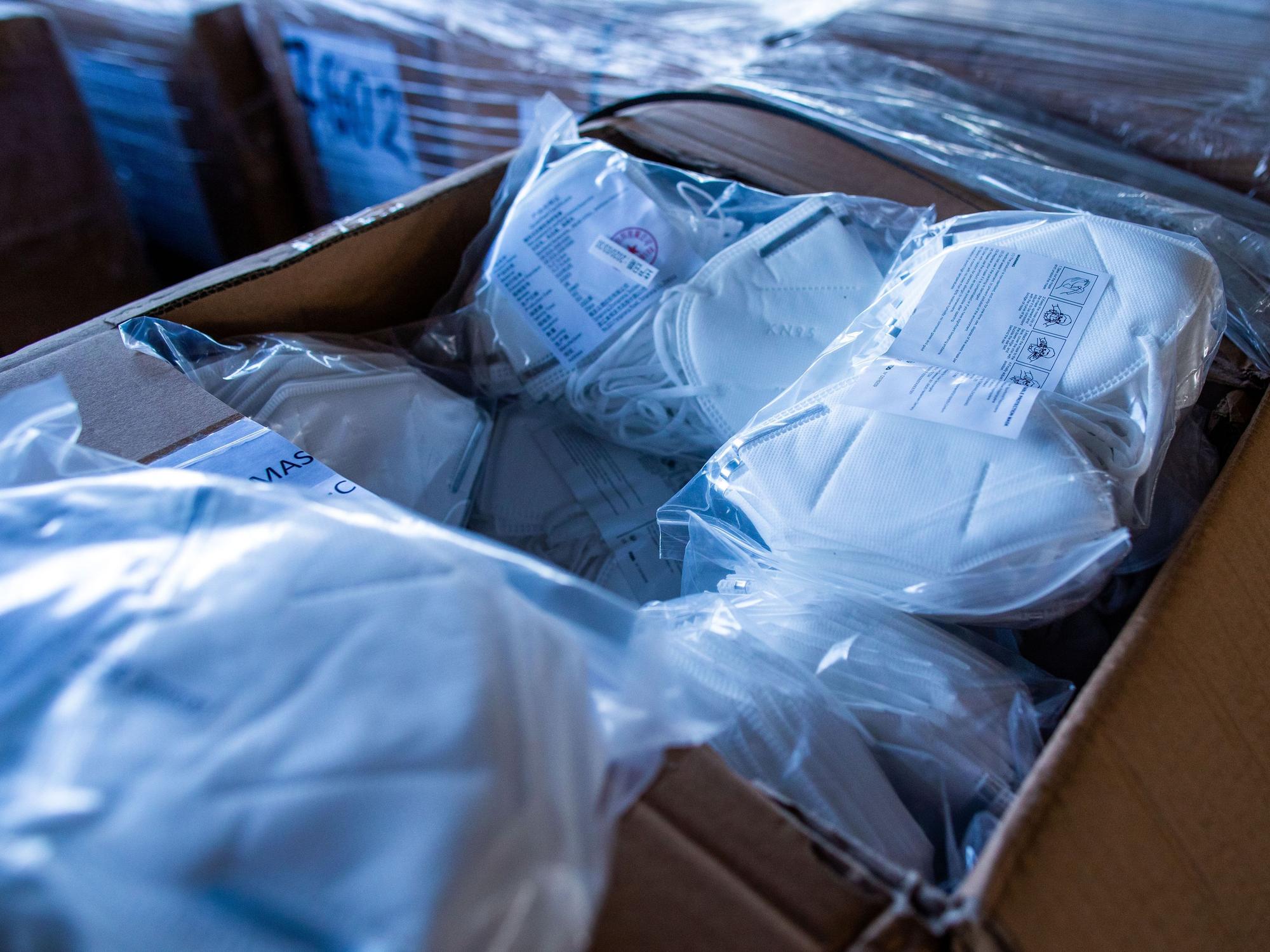 Ein offener Karton mit Mundschutzmasken steht im zentralen Materiallager für Schutzausrüstung und Hygienemittel.