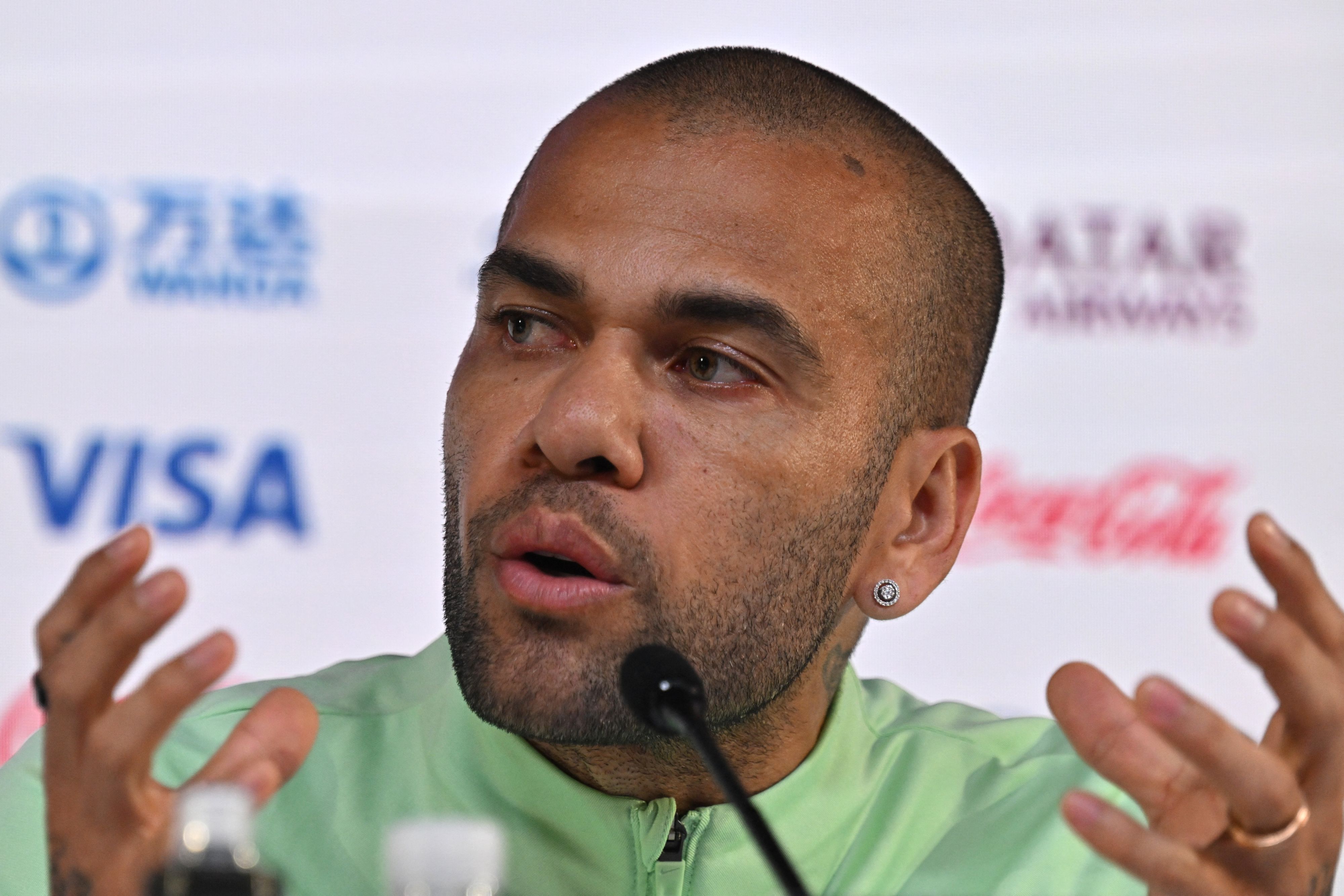 Dani Alves gestikuliert auf einer Pressekonferenz.