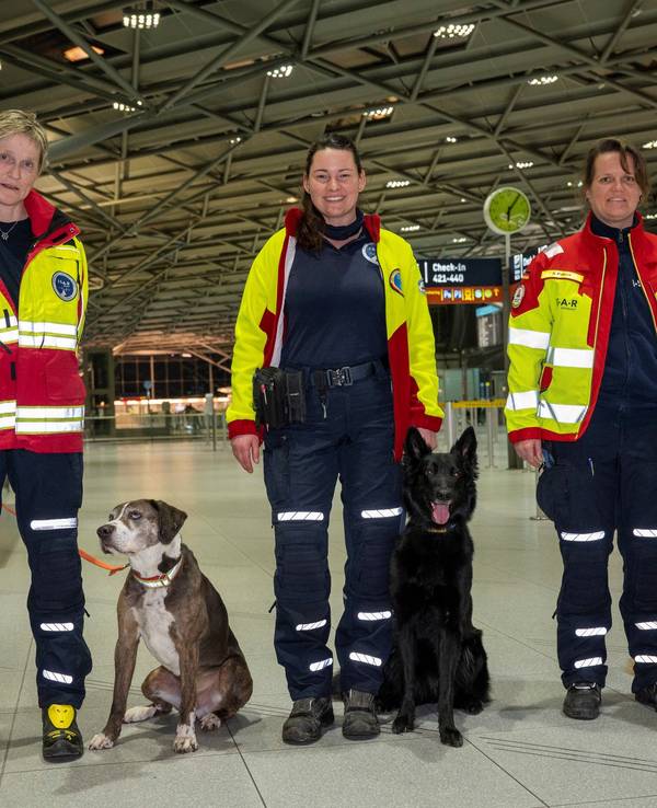 Frau Boysen, Frau Lambert und Frau Pilger mit ihren Personensuchhunden. Rettungskräfte mit Suchhunden checken am Flughafen ein um Erdbebenopfer in der Türkei zu helfen.