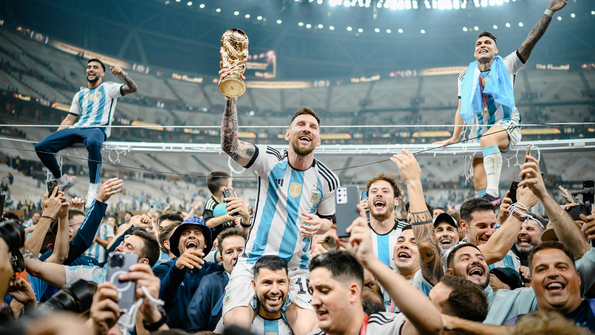 Lionel Messi (M) aus Argentinien wird nach seinem Triumph im WM-Finale von Sergio Agüero auf die Schultern genommen, um den argentinischen Fans den WM-Pokal zu präsentieren.