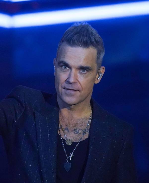 Robbie Williams ballt eine Faust auf der Bühne.