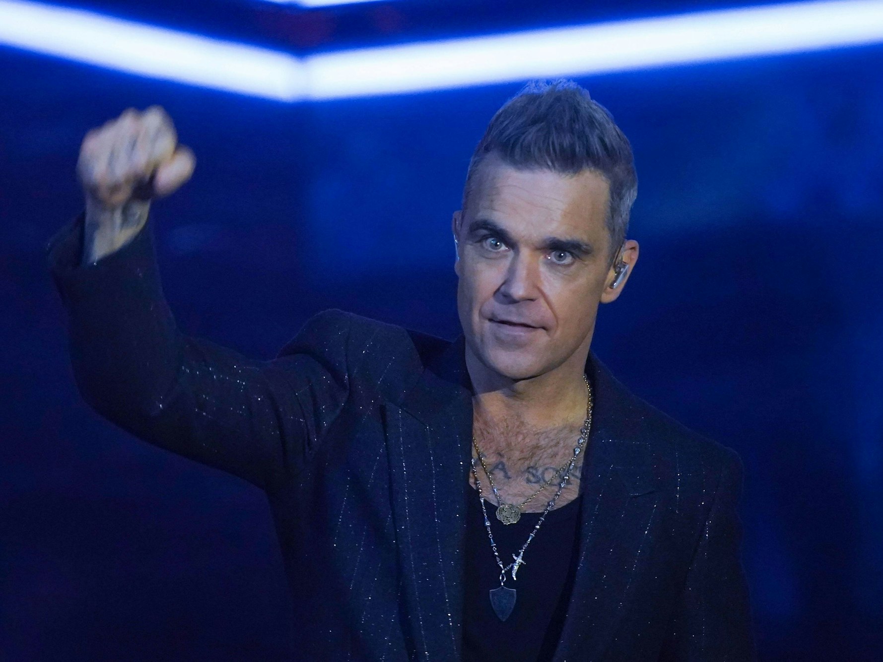 Robbie Williams ballt eine Faust auf der Bühne.