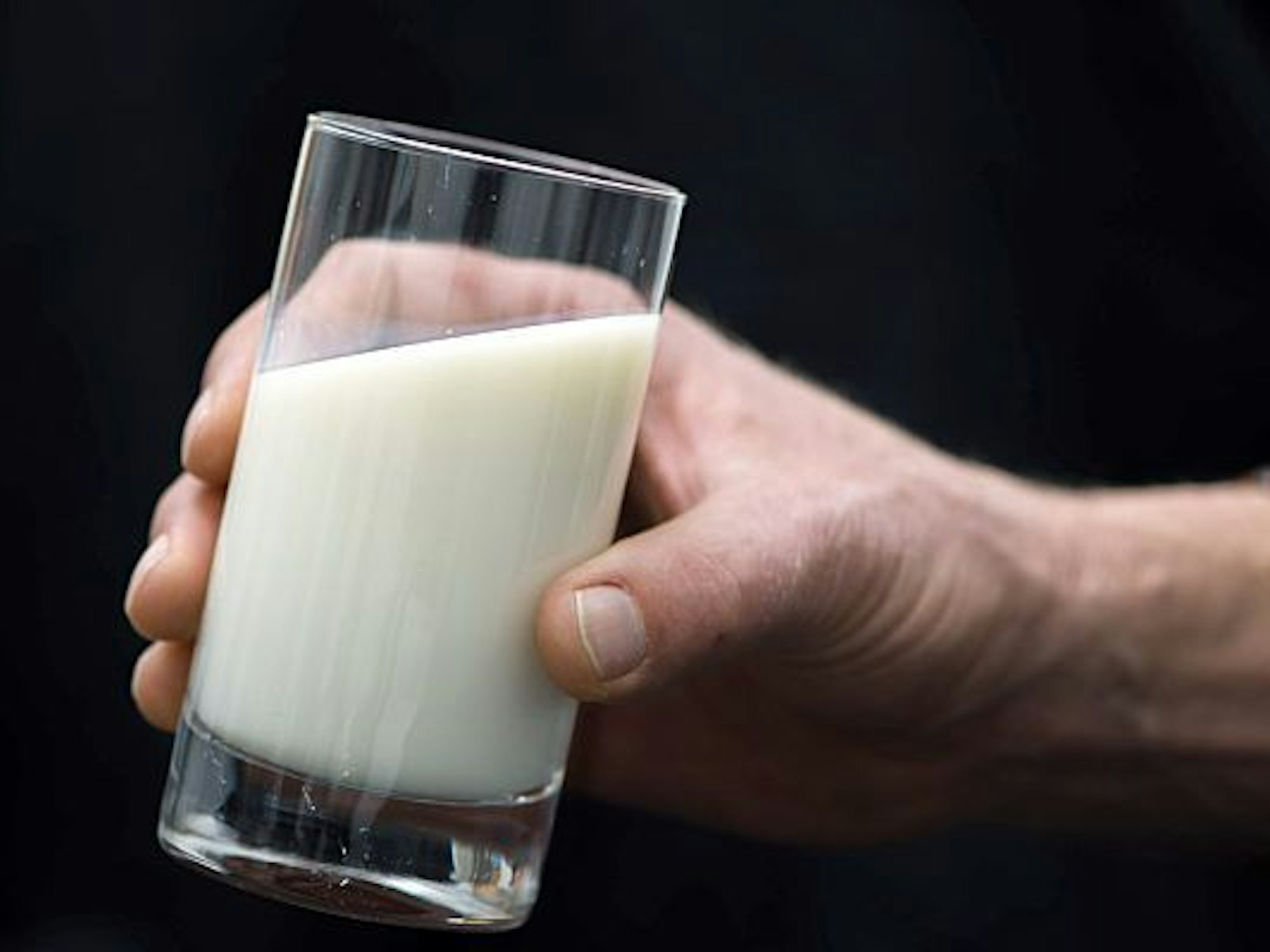 Ein Mann hält ein Glas Milch in der Hand. Milch und einige Milchprodukte werden teurer: Aldi hat nach neuen Lieferverträgen den Preis für Milch um 6 Cent je Liter in der untersten Preislage angehoben.