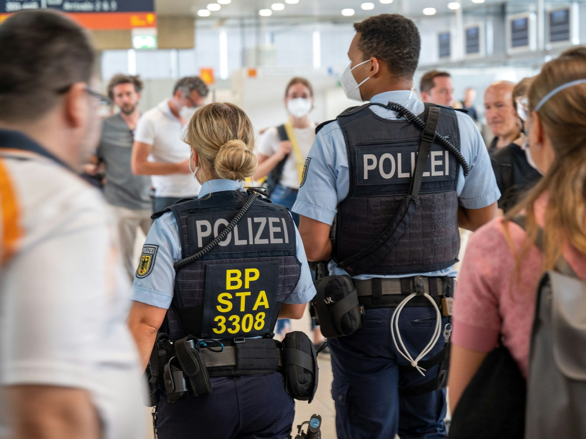 Eine Beamtin und ein Beamter der Bundespolizei gehen durch den Flughafen Köln/Bonn.