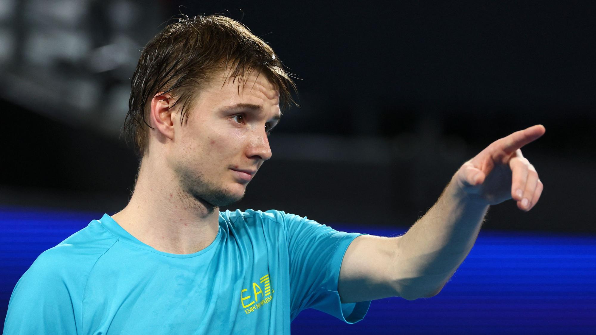 Alexander Bublik reagiert nach einem Ballwechsel und zeigt auf etwas.