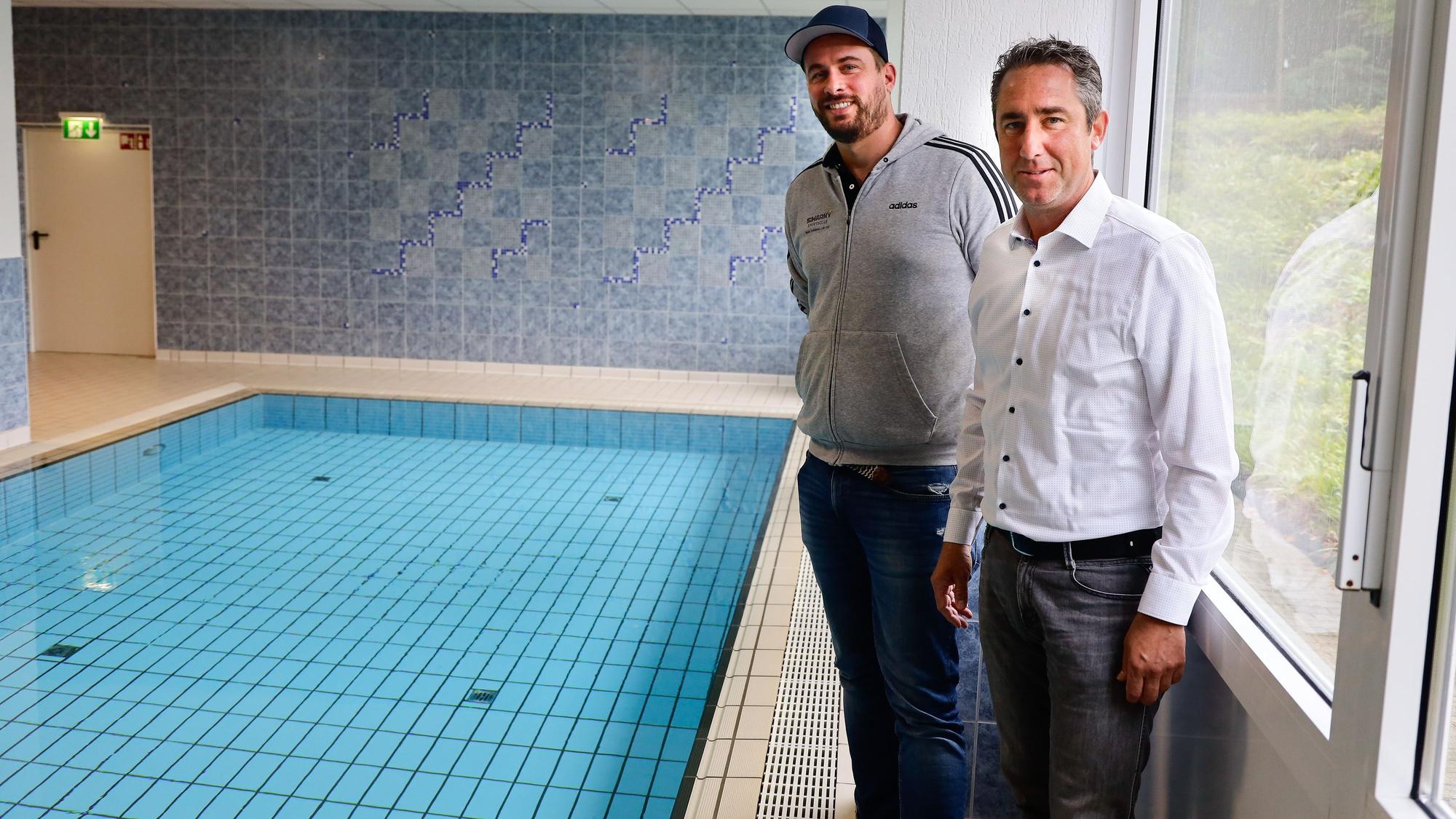 Schwimmlehrer Martin Becker (mit Kappe) von der Schwimmschule Sharky und Oliver Seeck, Vorsitzender im Sportausschuss Stadt Köln, präsentieren das Konzept der mobilen Schwimmpoolcontainer.