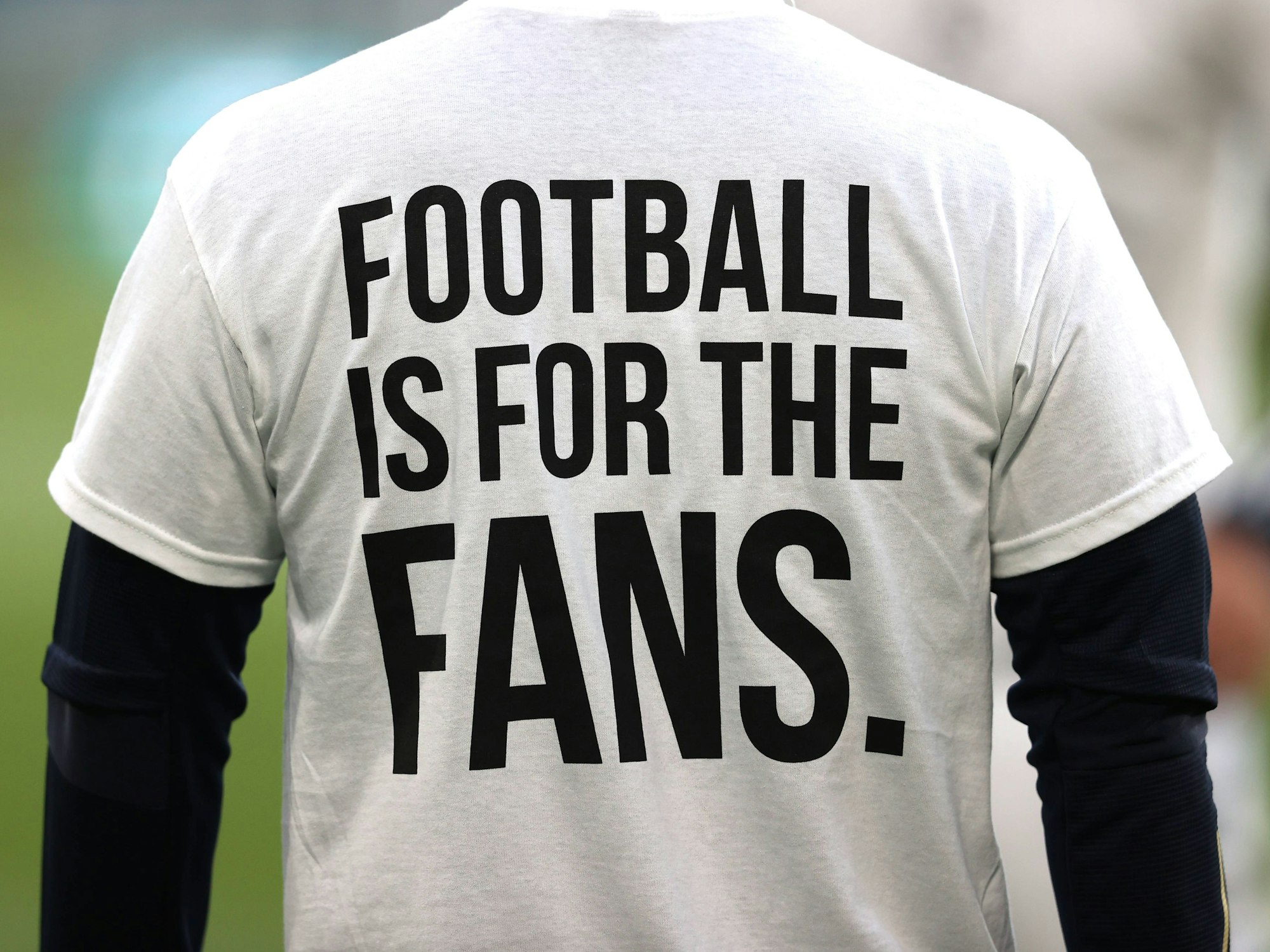 Ein Fan trägt ein T-Shirt mit der Aufschrift „FOOTBALL IS FOR THE FANS“.