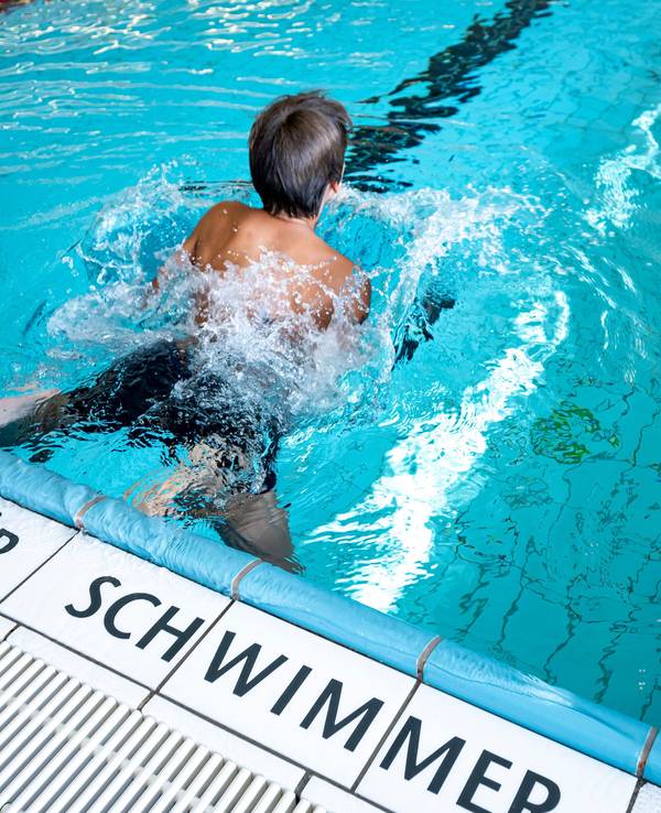 Ein Kind schwimmt im Stadtbad Märkisches Viertel. Auf den Fliesen steht die Aufschrift "nur für Schwimmer".