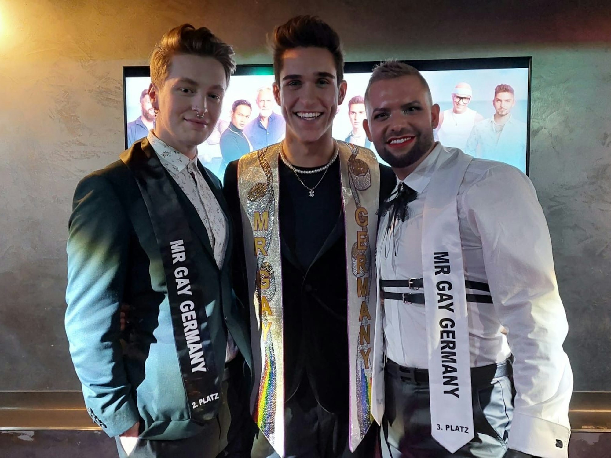 Der neue „Mr. Gay Germany“ Lukas steht zwischen Alvin (l., Platz zwei) und Dany aus München, der den dritten Platz erreichte. Am 9. Februar 2023 wurde Lukas als Sieger in der queeren Kölner Bar „Exile“ gekürt.