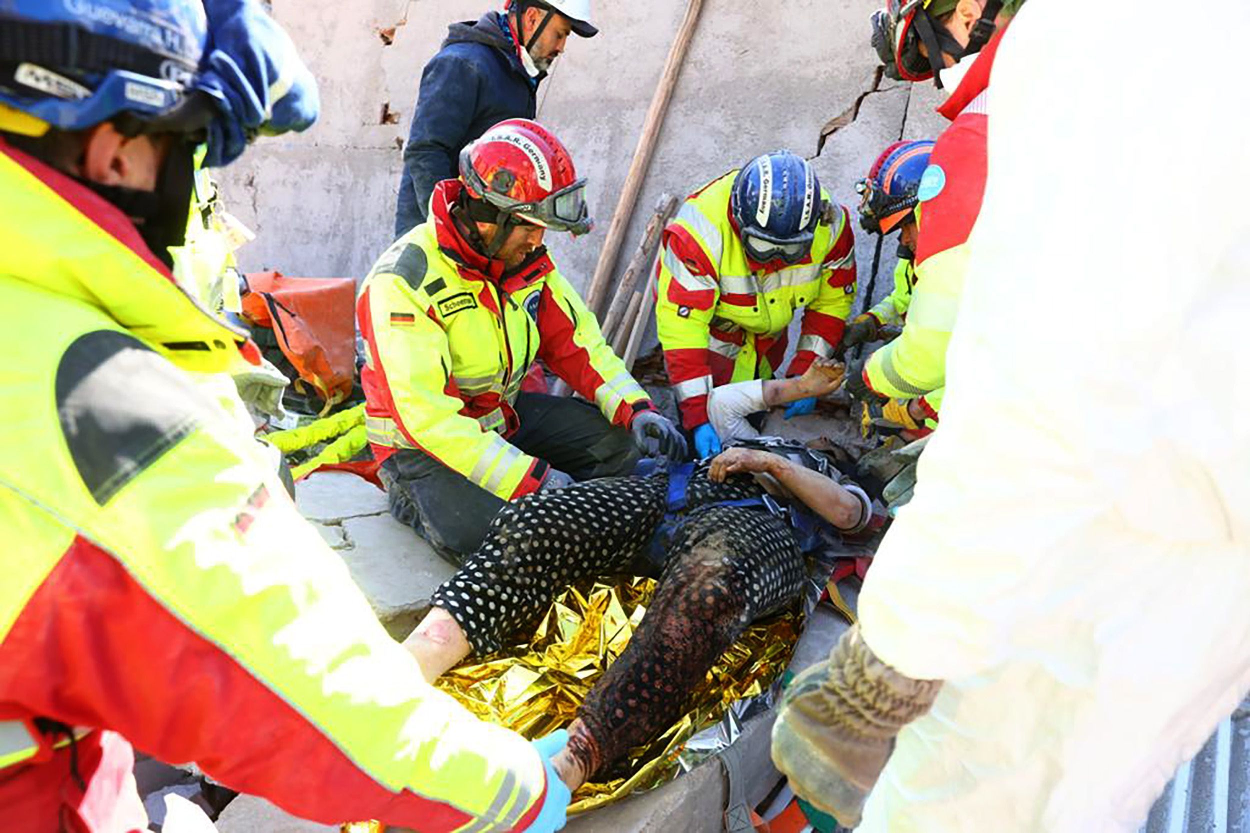 Rettungskräfte heben die Frau aus den Trümmern.