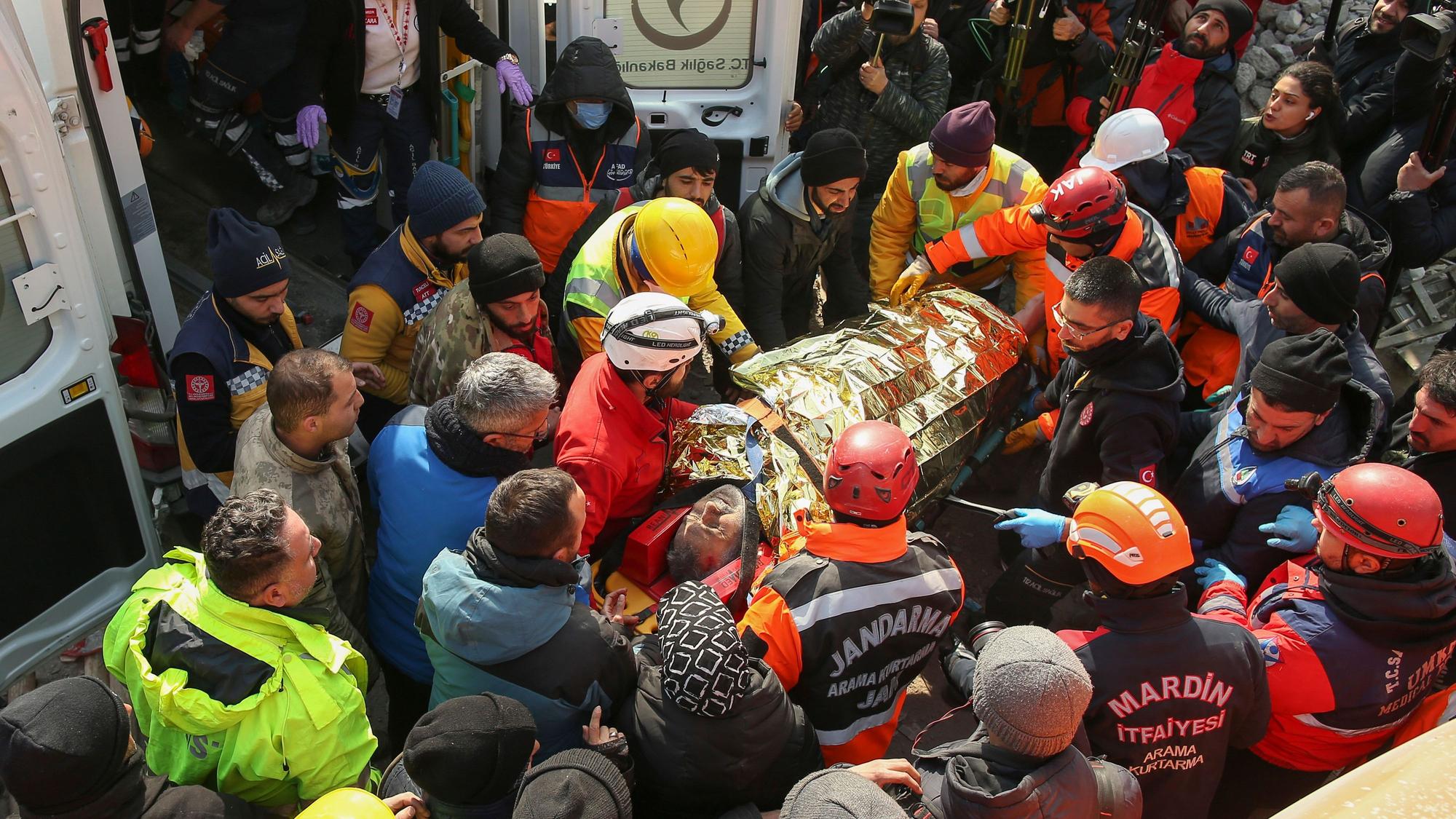 Türkische Rettungskräfte tragen den 60-jährigen Eyup Ak zu einem Krankenwagen, nachdem sie ihn 104 Stunden nach dem Erdbeben lebend aus einem eingestürzten Gebäude geborgen haben.