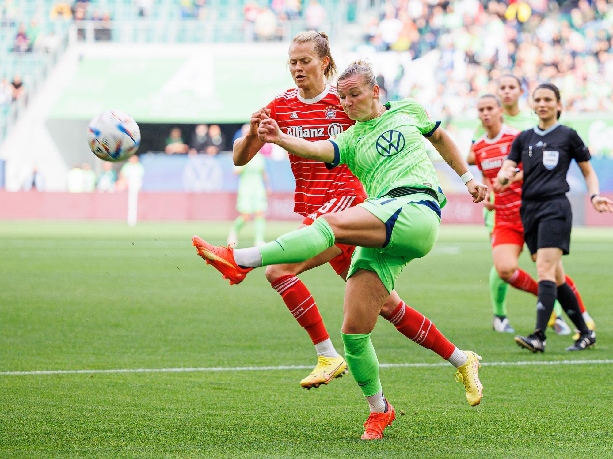 Wolfsburgs Alexandra Popp (r) schießt neben Münchens Maximiliane Rall (l).