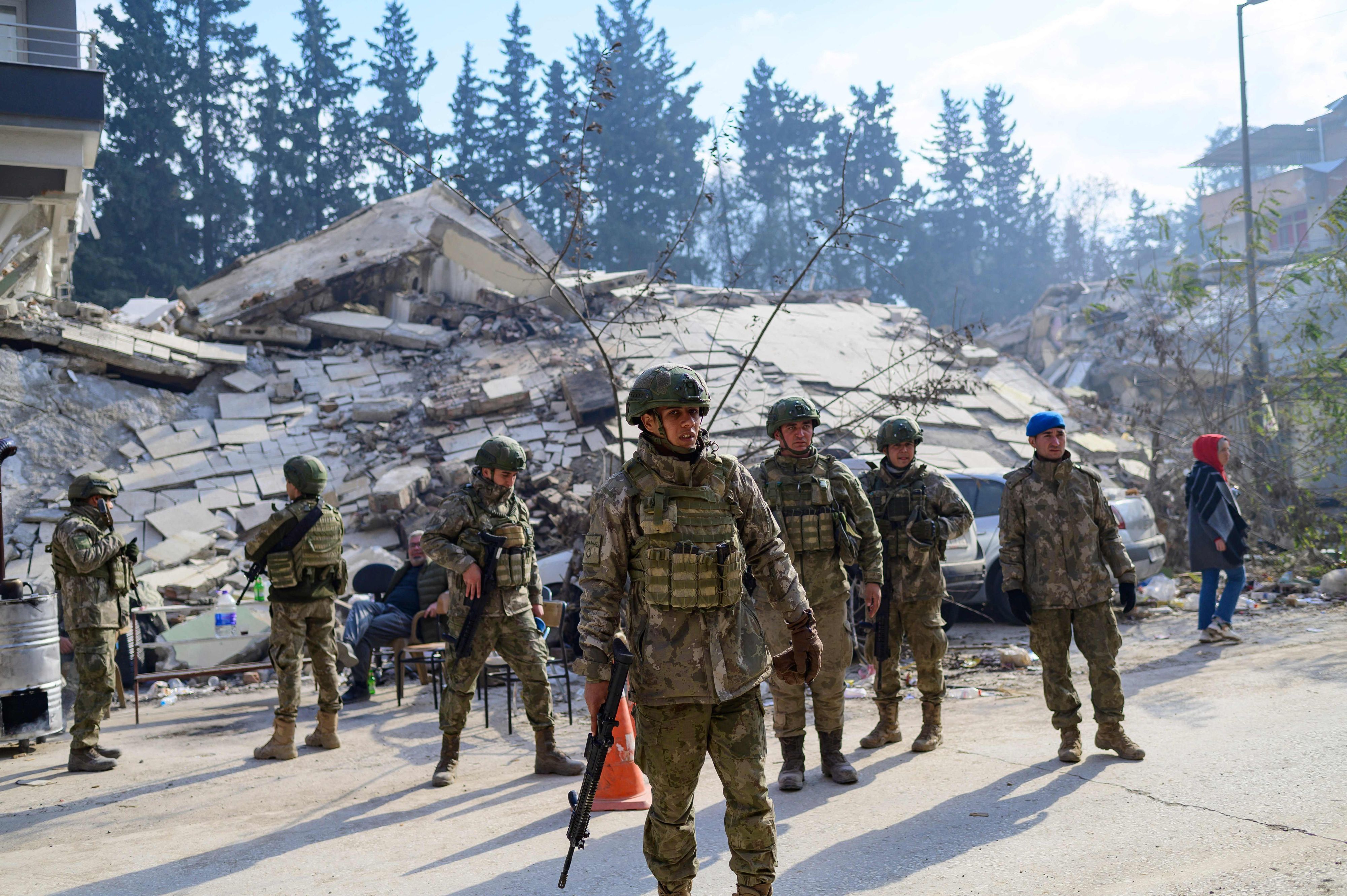 Türkische Soldaten stehen am 11. Februar neben einem zerstörten Gebäude in Hatay, nachdem ein Erdbeben der Stärke 7,8 den Südosten des Landes erschüttert hat. Die Sicherheitslage in der Region verschlechtert sind zunehmend, auch deutsche Rettungskräfte sind in Gefahr und müssen sich zurückziehen.