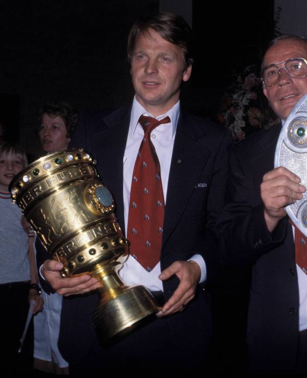 Manager Karl-Heinz Thielen und Trainer Hennes Weisweiler präsentieren beim 1. FC Köln den DFB-Pokal und die Meisterschale.