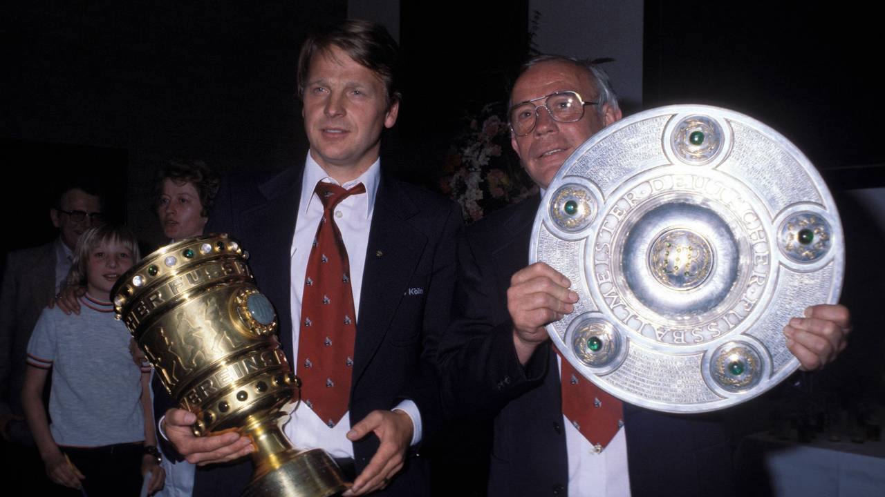 Manager Karl-Heinz Thielen und Trainer Hennes Weisweiler präsentieren beim 1. FC Köln den DFB-Pokal und die Meisterschale.