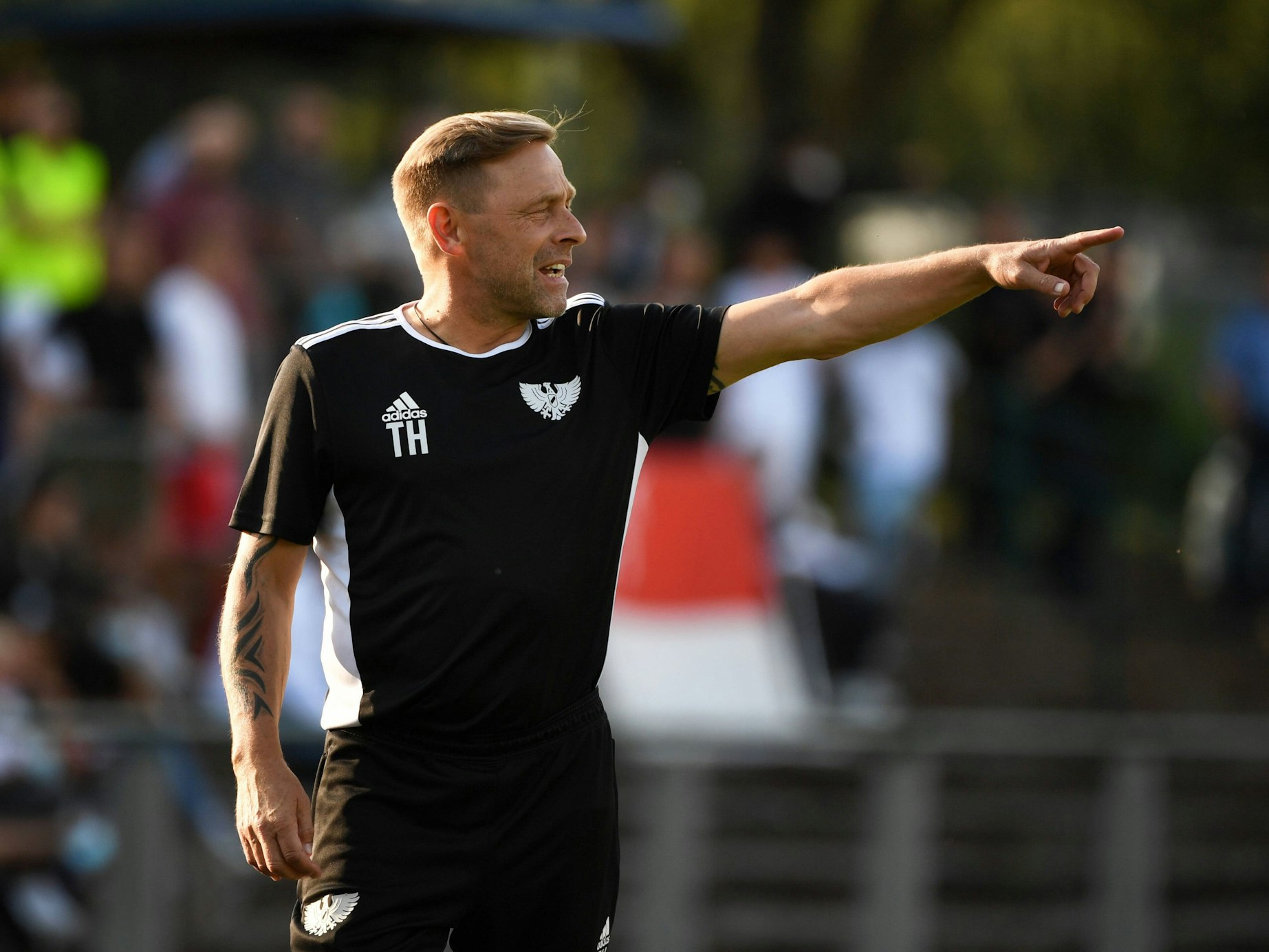 Thomas Häßler zeigt auf etwas.