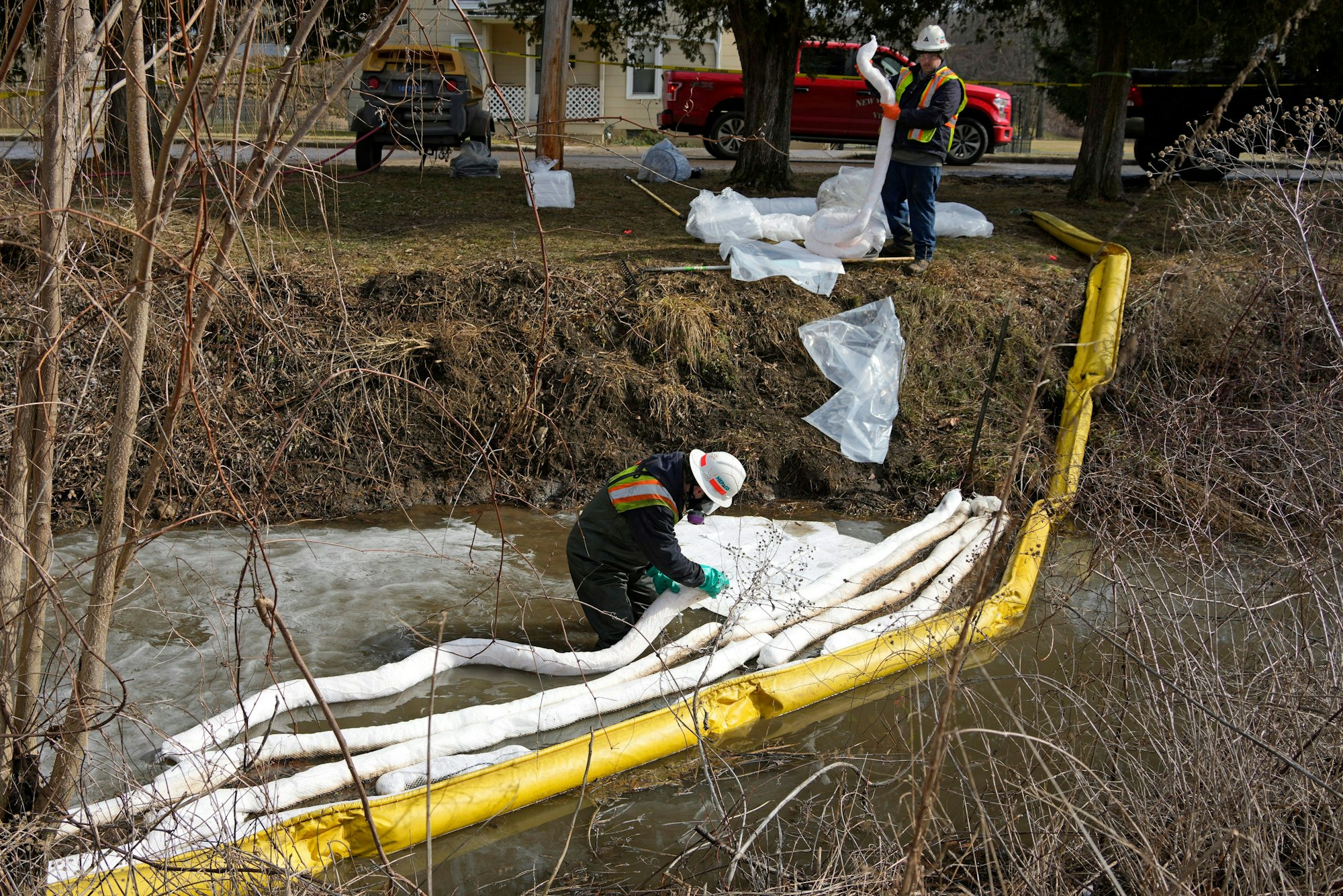 Arbeiter platzieren eine Schutzbarriere im Wasser in Ohio nach der Zugkatastrophe.