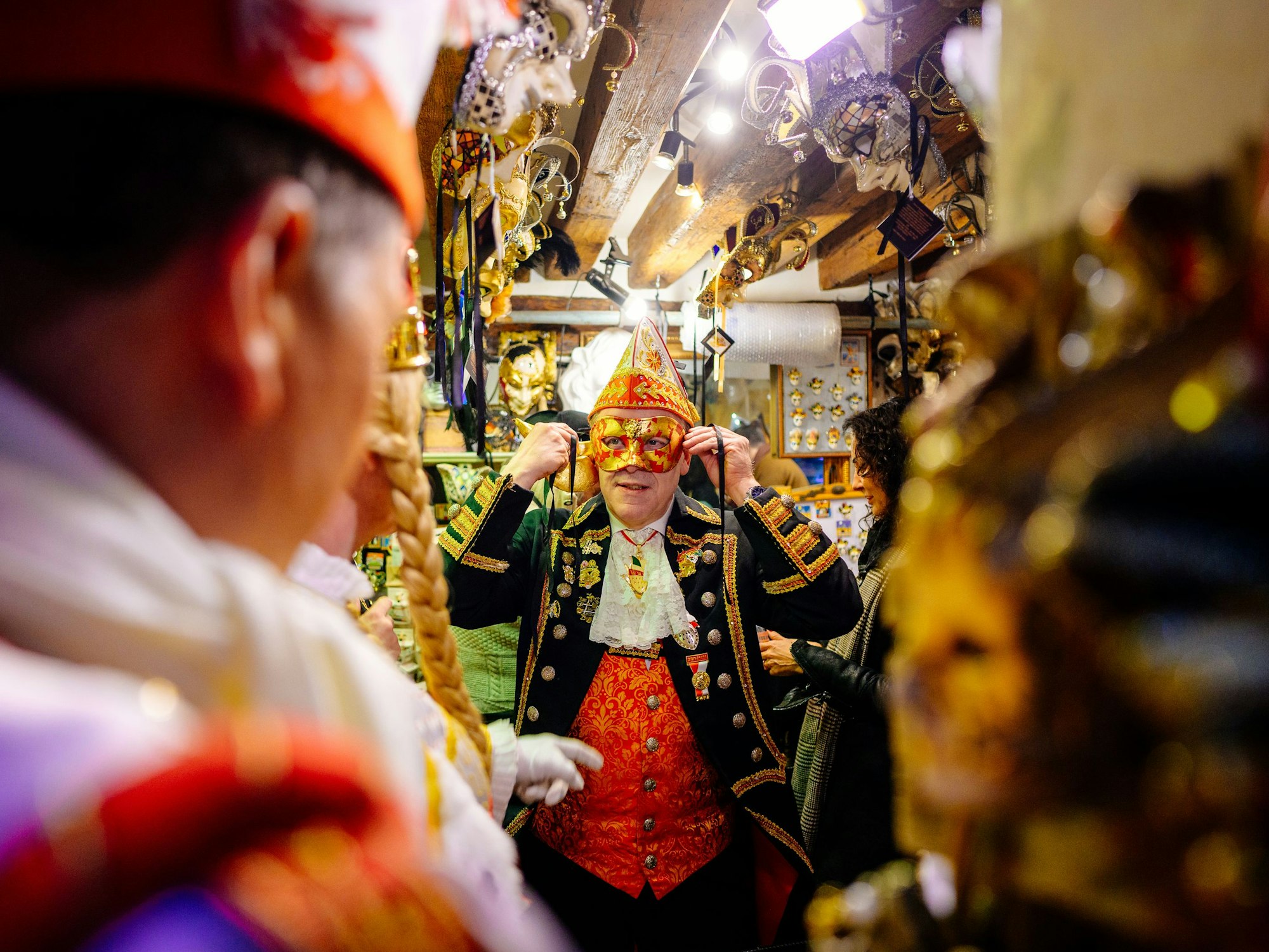 Christoph Kuckelkorn probiert eine Karnevalsmaske an.