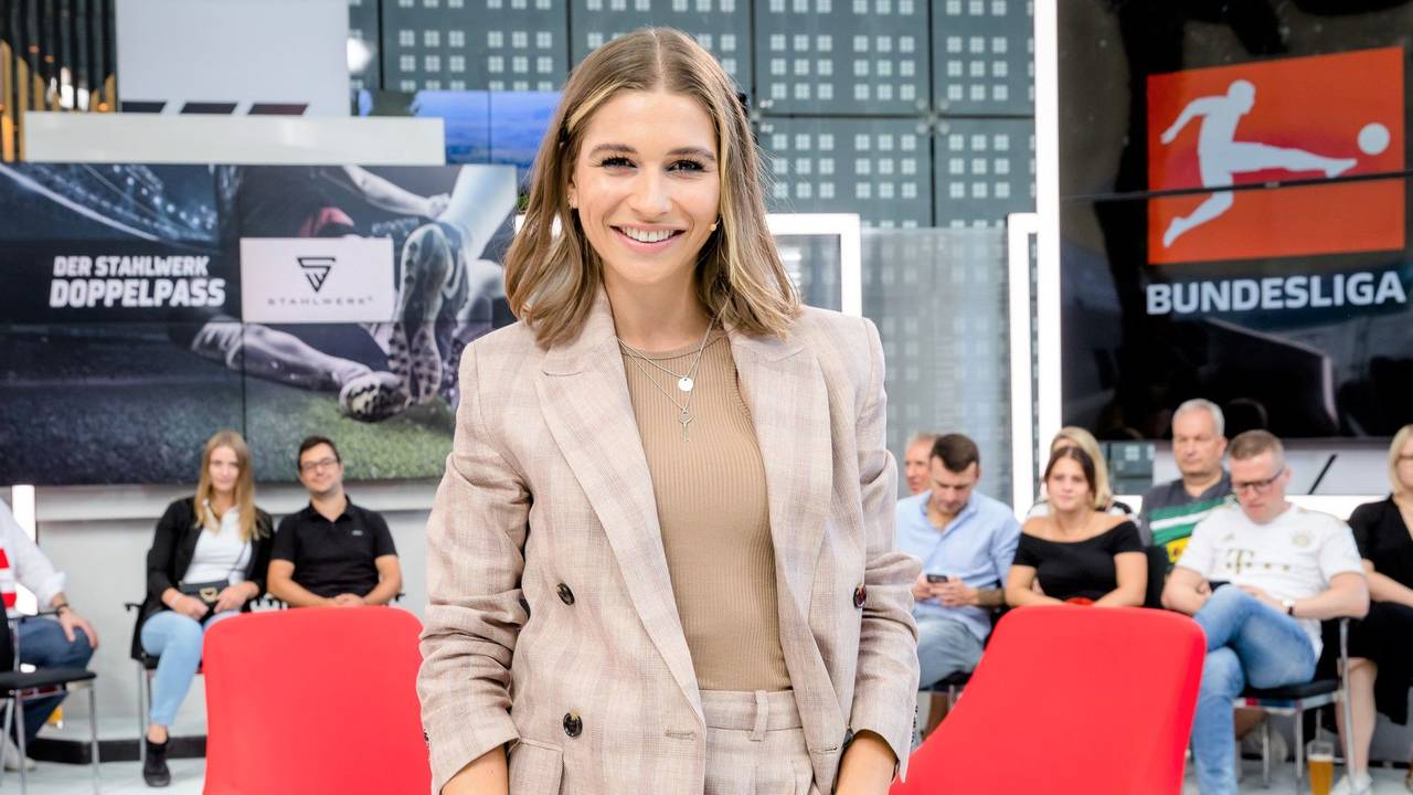 Jana Wosnitza lächelt am Doppelpass-Set in die Kamera.