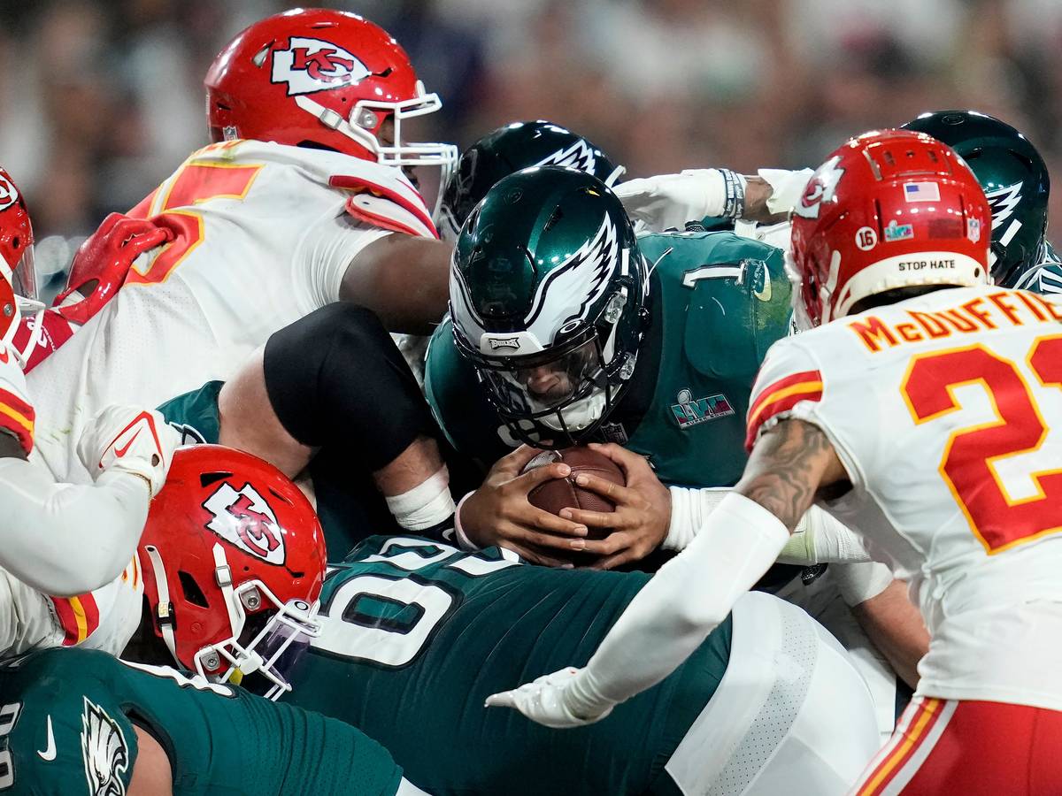 Eagles-Quarterback Jalen Hurts wirft sich beim Super Bowl mit dem Ball in der Hand ins Getümmel.
