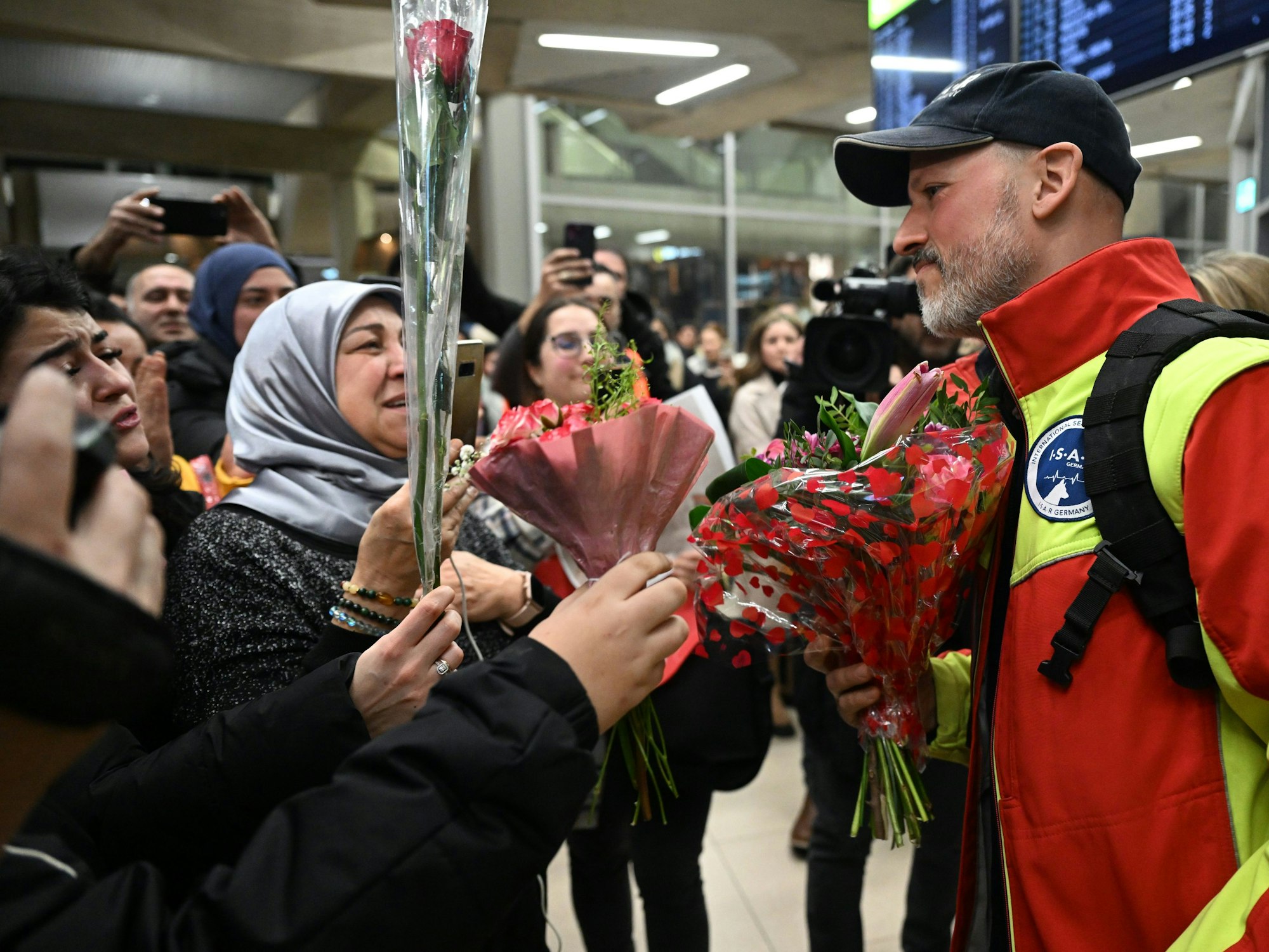 Daniel Lankers, Notarzt, wird am 13. Februar 2023 von jubelnden Menschen auf dem Flughafen Köln/Bonn begrüßt.