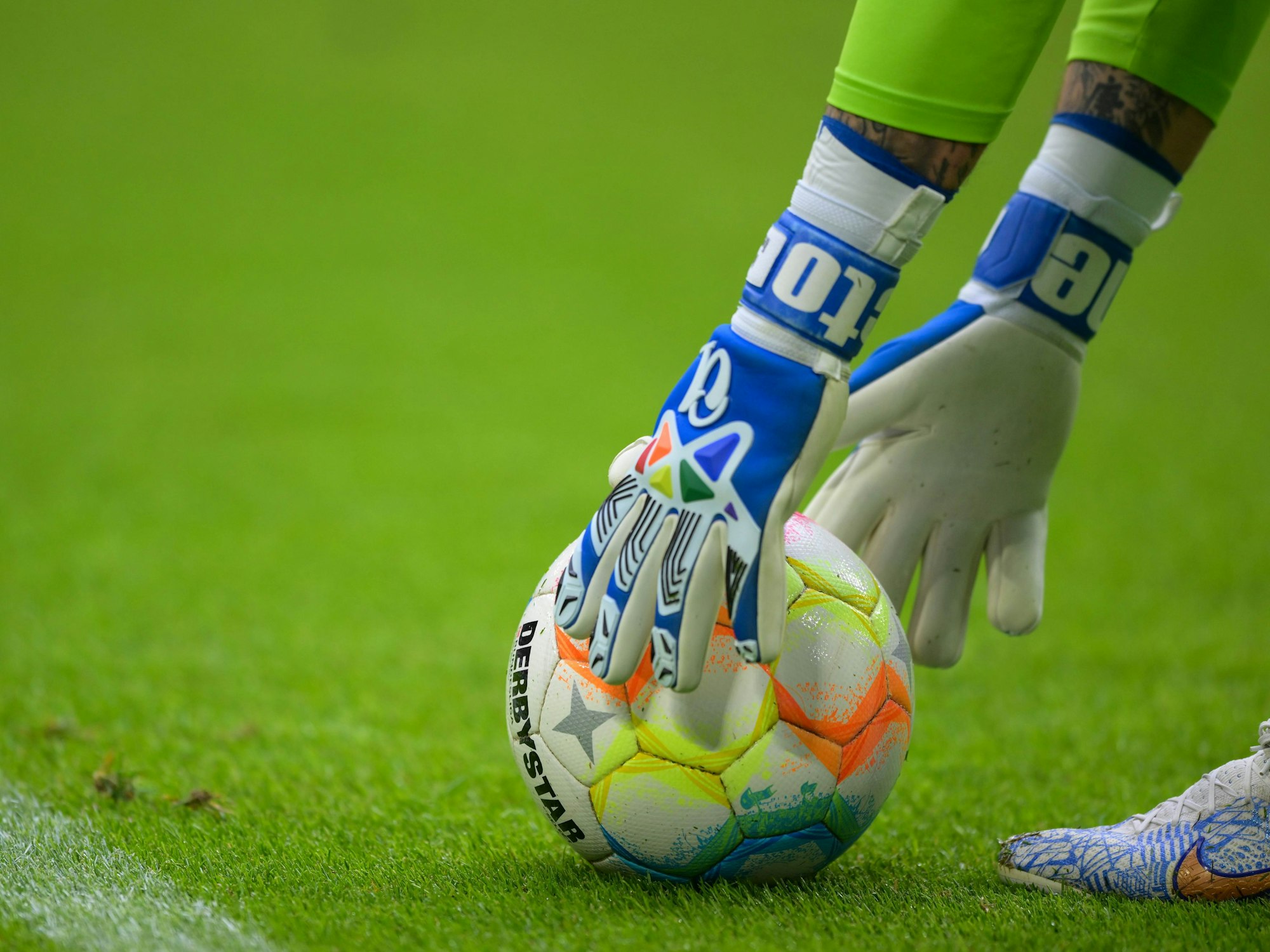 Hände in Torwarthandschuhen greifen nach dem Ball.
