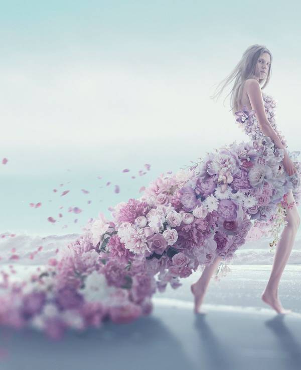 Eine junge Frau in einem Blütenkleid am Strand