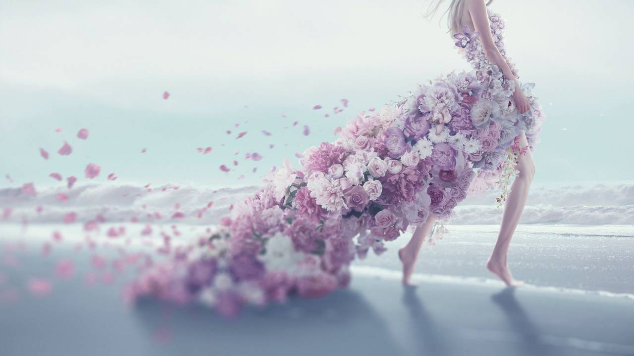 Eine junge Frau in einem Blütenkleid am Strand