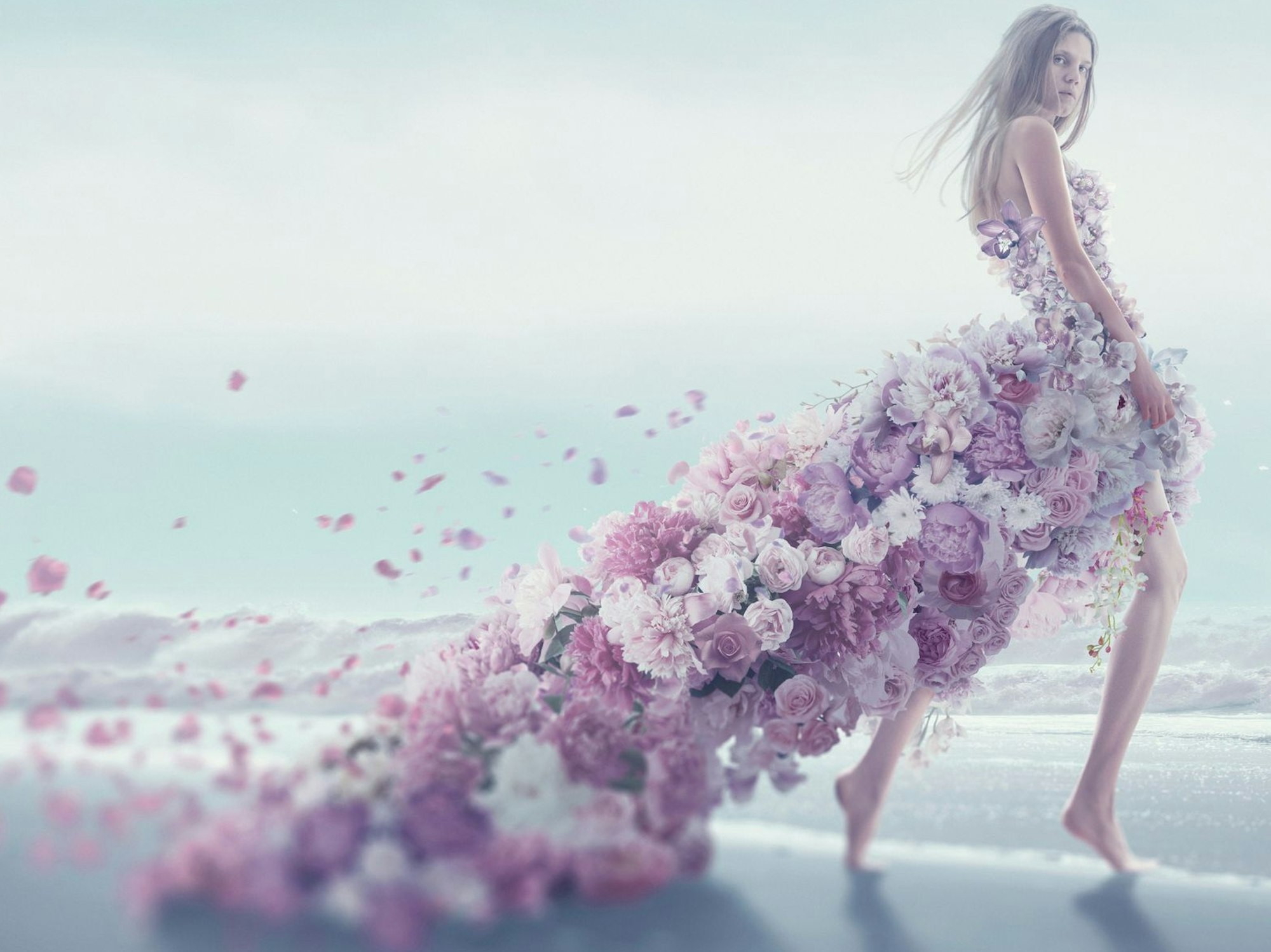 Eine junge Frau in einem Blütenkleid am Strand