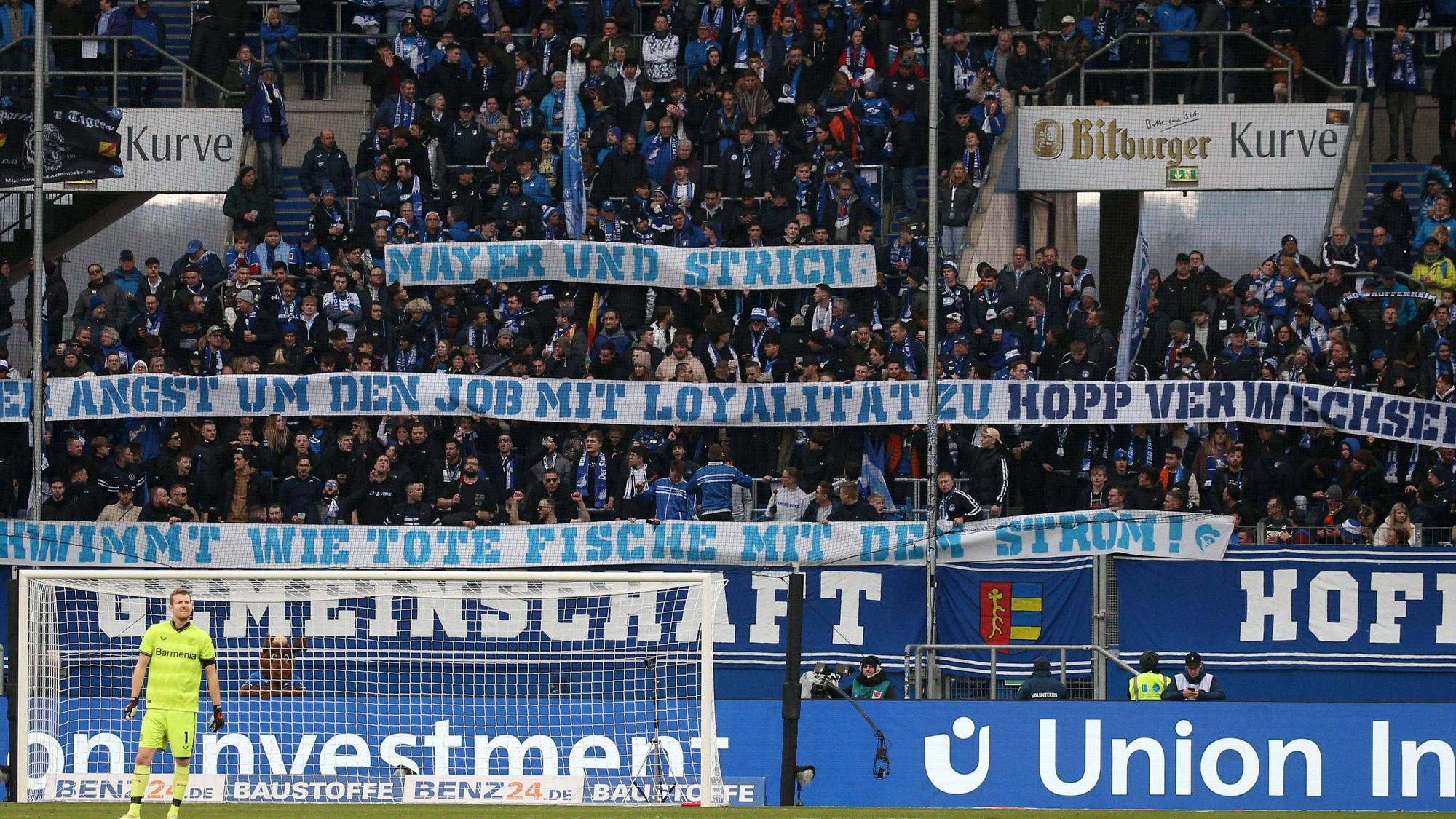 Hoffenheimer Fans zeigen ein Plakat. Darauf ist zu lesen: Mayer und Strich: Wer Angst um den Job mit Loyalität zu Hopp verwechselt, schwimmt wie tote Fische mit dem Strom!