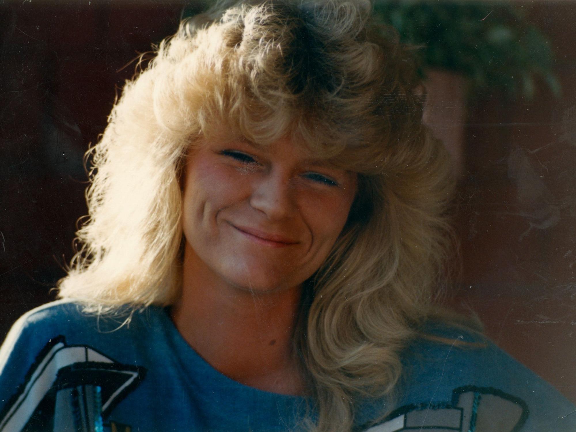 Petra Nohl, eine Blondine mit lockigen Haaren, schaut mit freundlichem Grinsen in die Kamera.