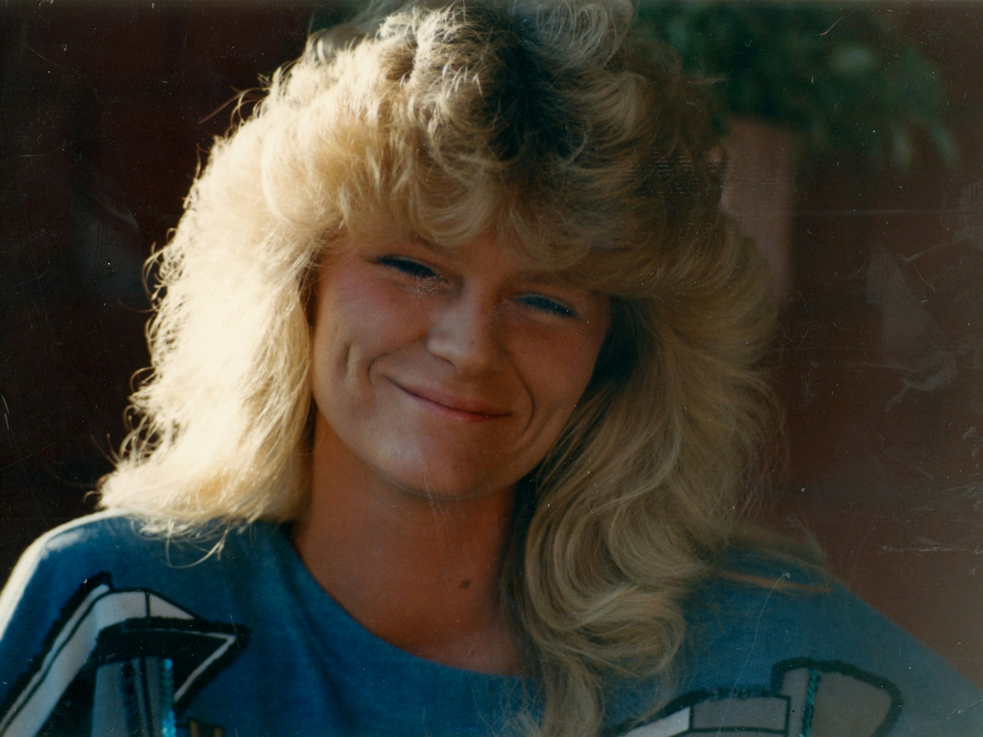 Petra Nohl, eine Blondine mit lockigen Haaren, schaut mit freundlichem Grinsen in die Kamera.