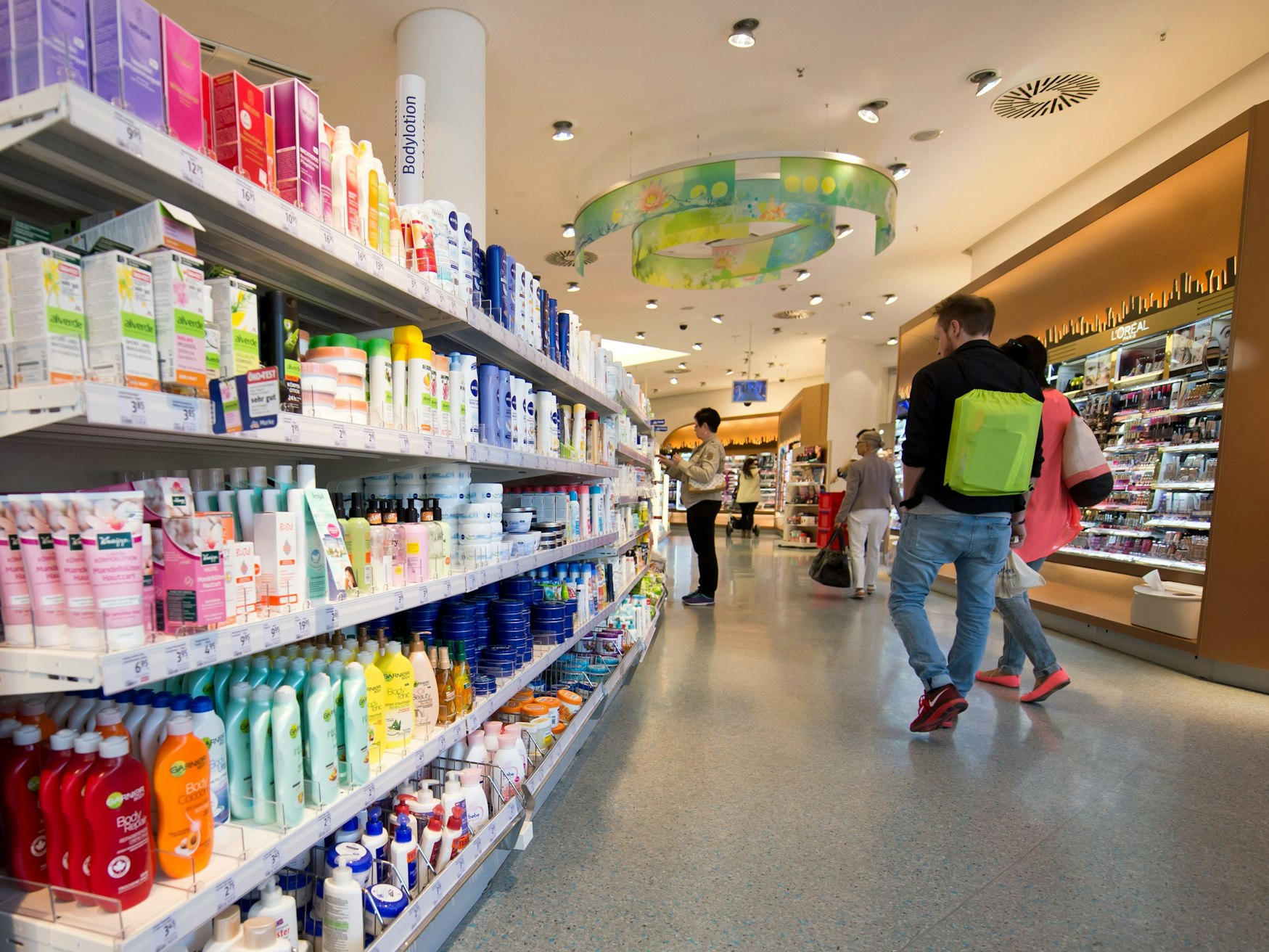 Kunden gehen durch einen Drogeriemarkt dm in Stuttgart (Baden-Württemberg).