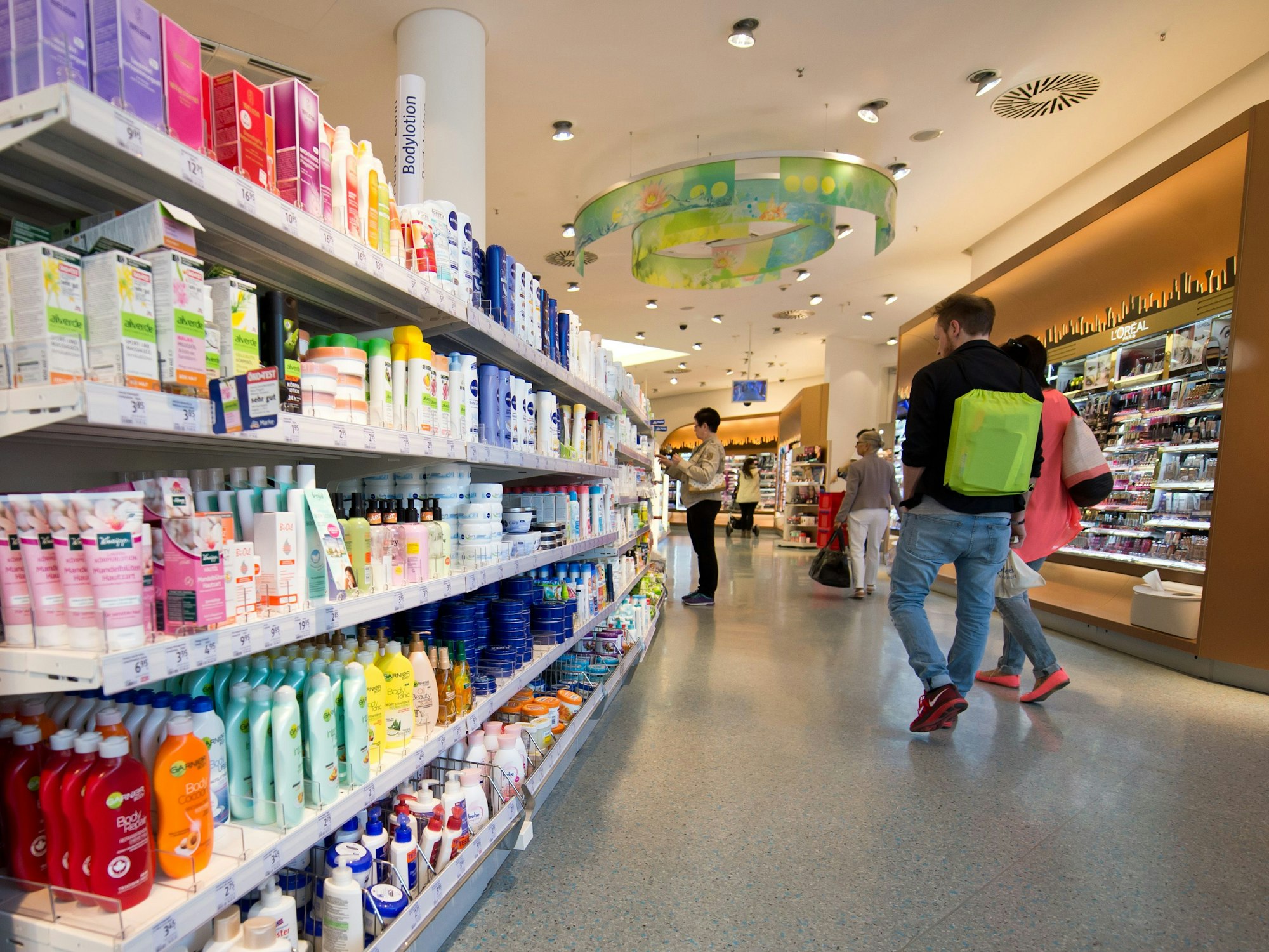Kunden gehen durch einen Drogeriemarkt dm in Stuttgart (Baden-Württemberg).