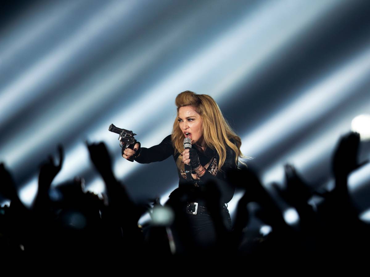 Die US-amerikanische Sängerin Madonna steht in der Lanxess-Arena in Köln mit einer Waffe auf der Bühne.