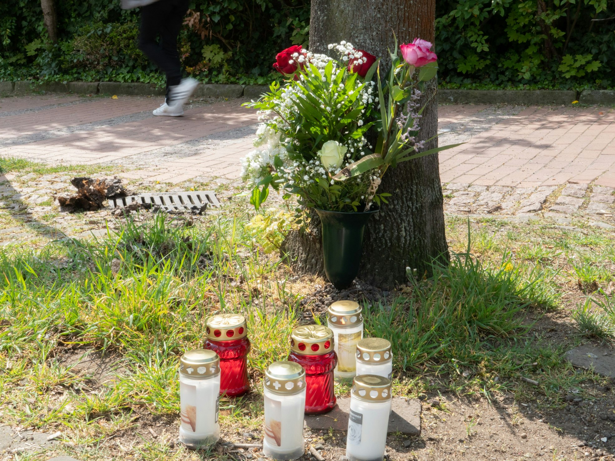 Blumen und Kerzen stehen am Tatort in der Innenstadt von Burgdorf bei Hannover.