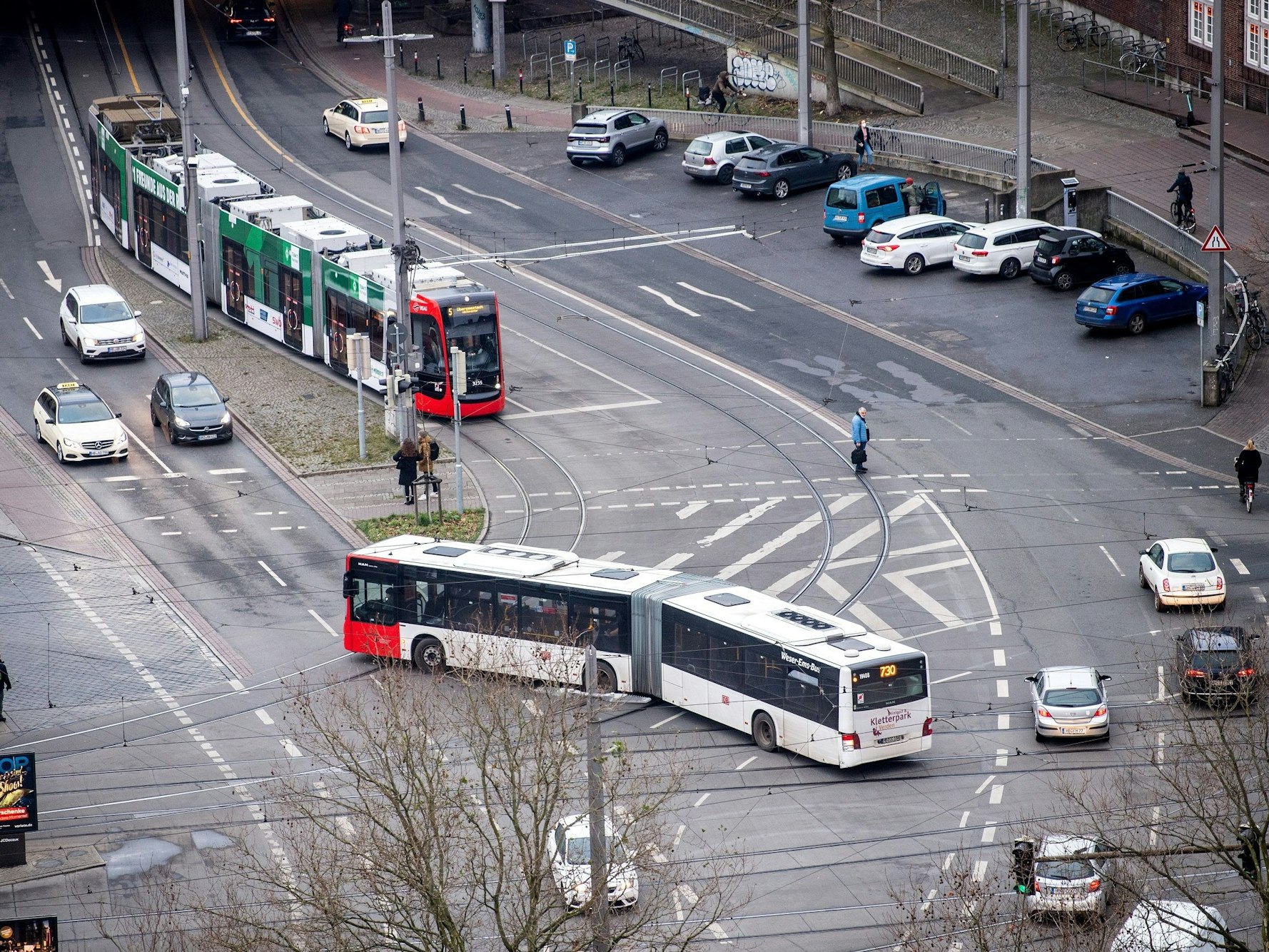 Ein Bus und eine Straßenbahn fahren auf einer Straße in Bremen.