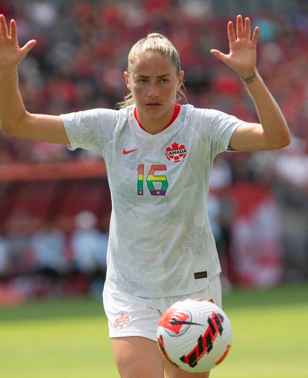 Fußballerin Janine Beckie (Kanada) hebt auf dem Spielfeld die Hände hoch.