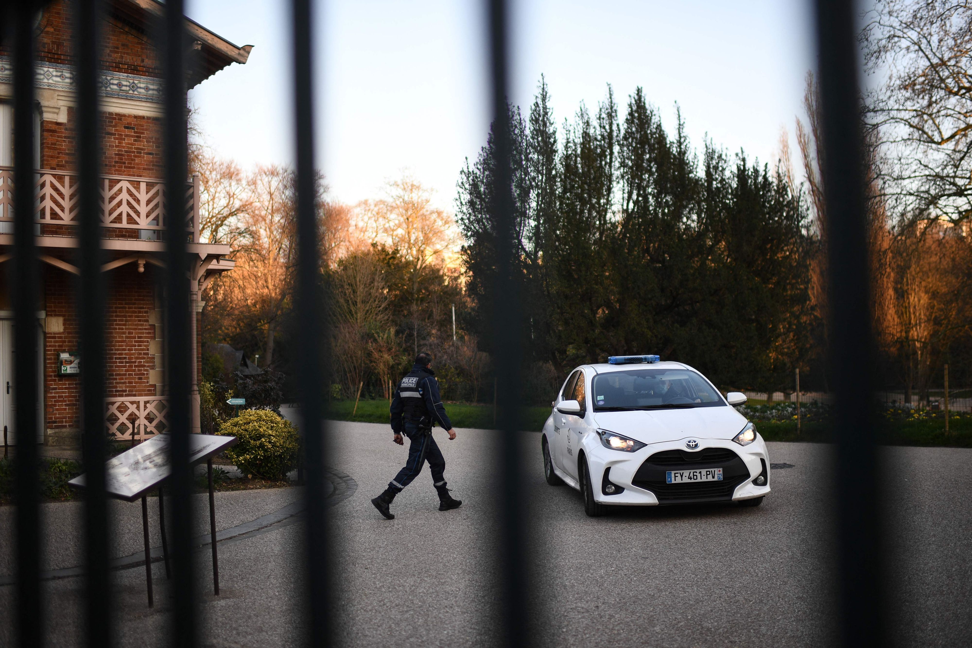 Ein Polizist geht im Park Buttes-Chaumont im 19. Arrondissement von Paris neben einem Auto des Pariser Sicherheitsdienstes spazieren.
