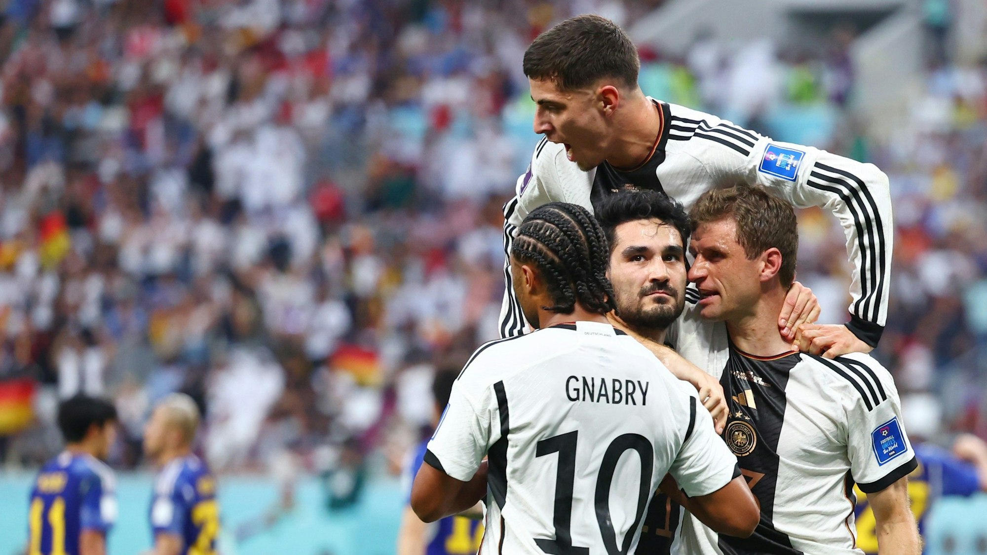 Die DFB-Stars Serge Gnabry (l.), Thomas Müller (r.) und Kai Havertz (oben) beglückwünschen Ilkay Gündogan zu seinem Tor bei der WM gegen Japan.
