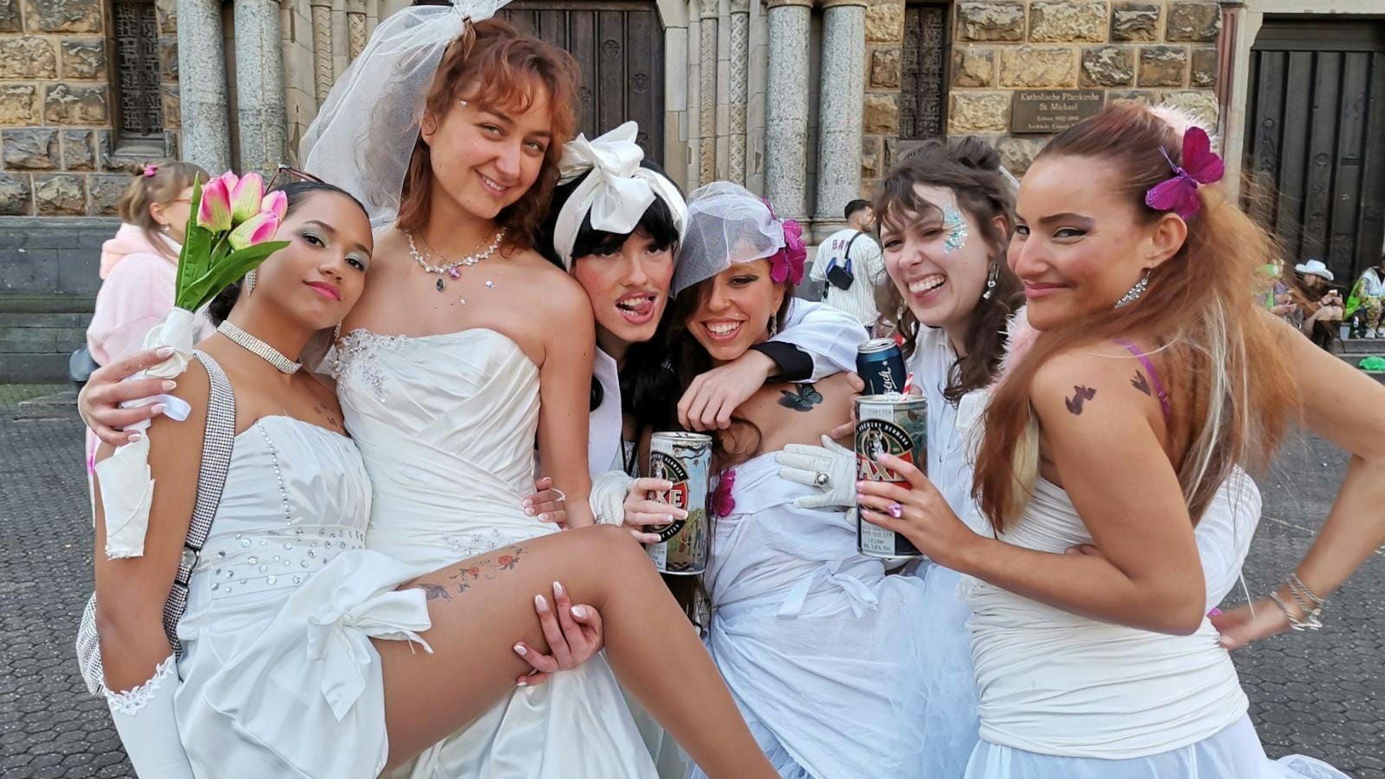 Sechs Frauen feiern am Brüssler Platz im Hochzeits-Outfit.