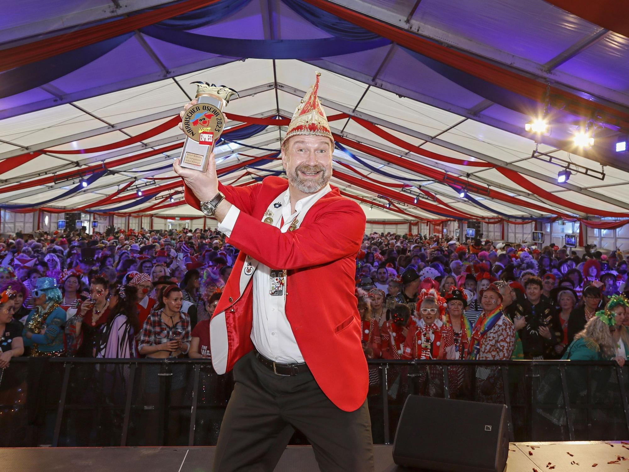 Volker Weininger "Der Sitzungspräsident" hält einen Pokal hoch.