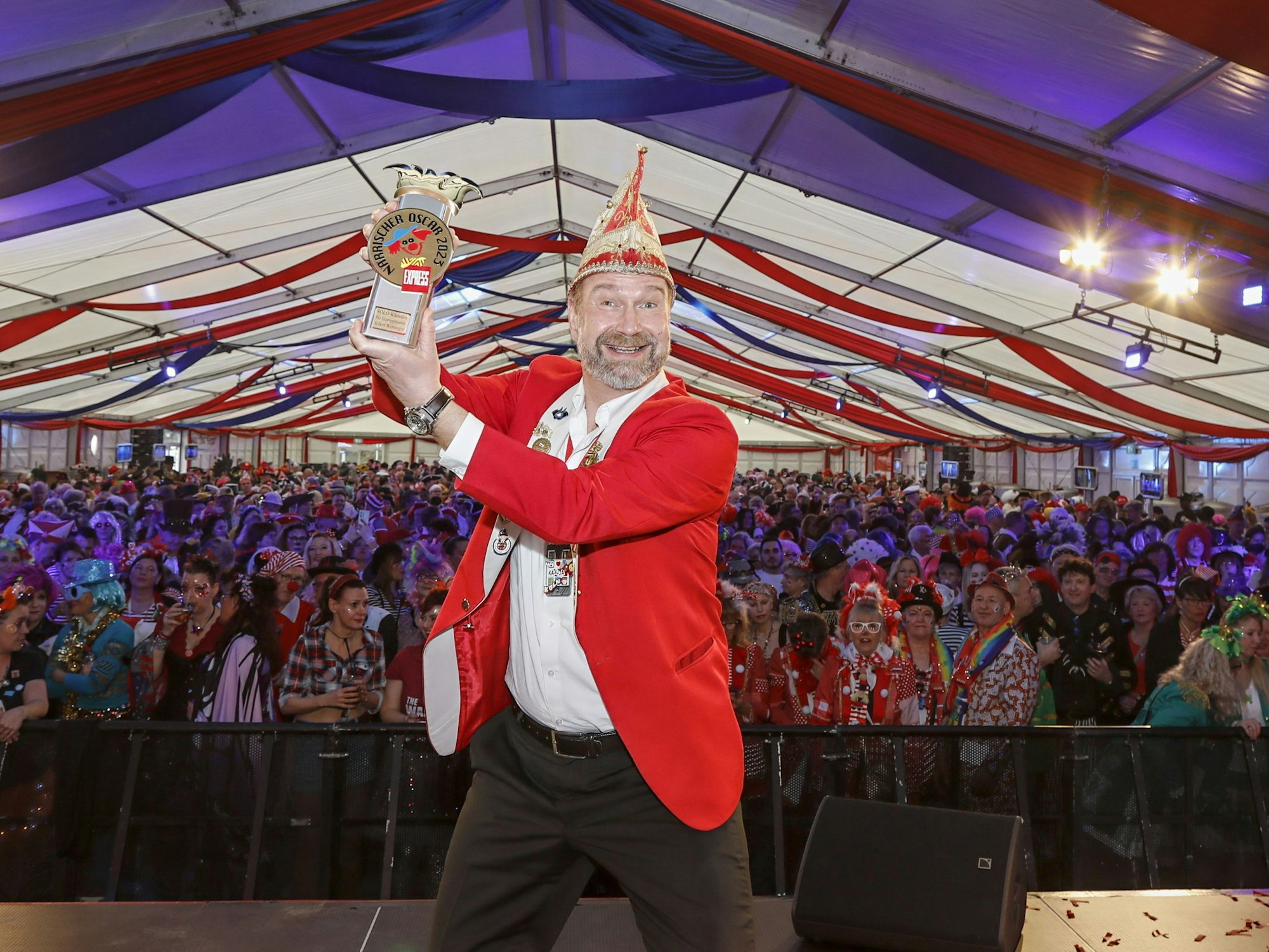 Volker Weininger "Der Sitzungspräsident" hält einen Pokal hoch.