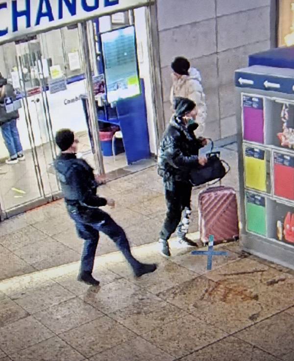 Ein mutmaßlicher Dieb hat die Tasche einer Reisenden gegriffen, während ein Bundespolizist keinen Meter von ihm entfernt ist.