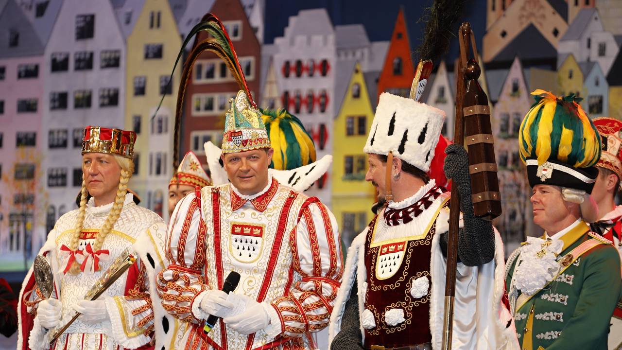 Das Kölner Dreigestirn steht auf einer Bühne.