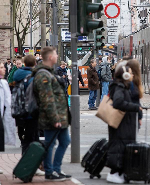 Menschen warten am Zülpicher Platz auf die KVB, im Hintergrund fährt eine Linie 9 heran.